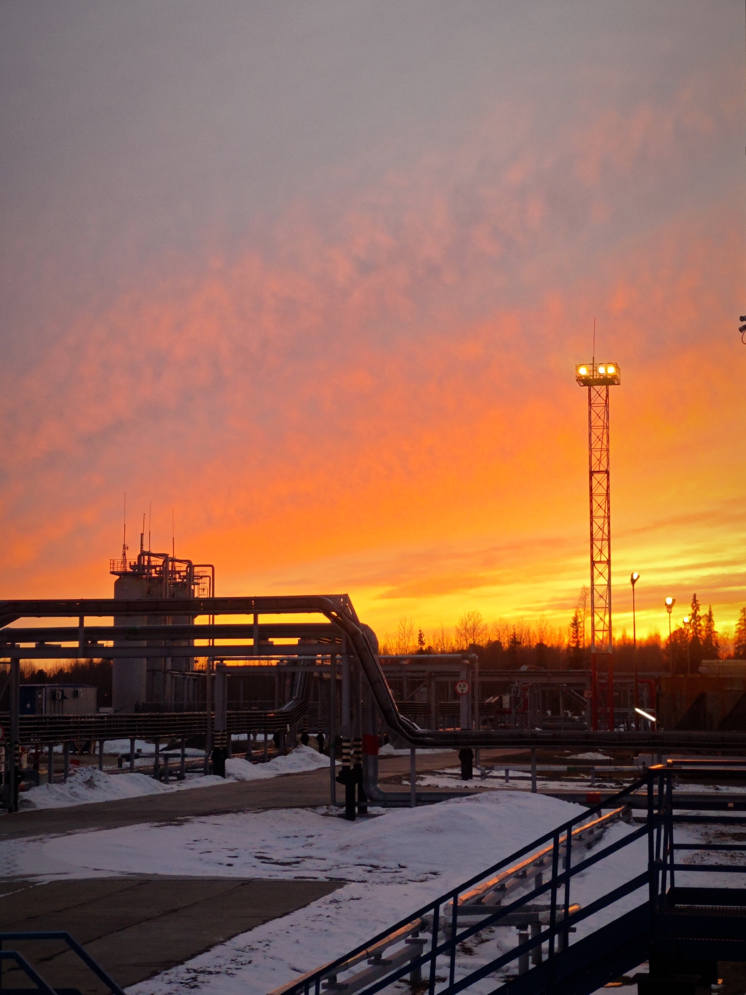 Russian industrial facility towers illuminated at sunset