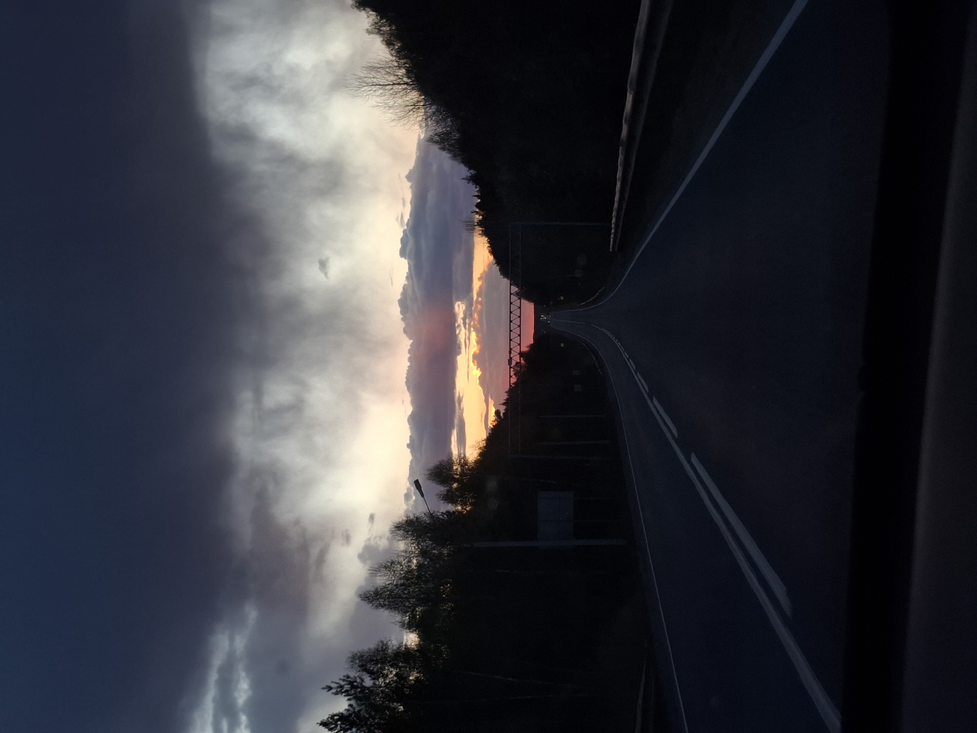 Sunset photograph captures tree-lined road in Chaykovsky, Russia