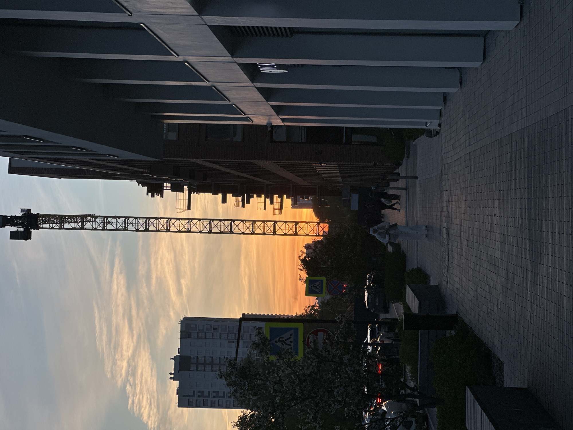 Sunset construction crane and modern buildings observed in Yekaterinburg