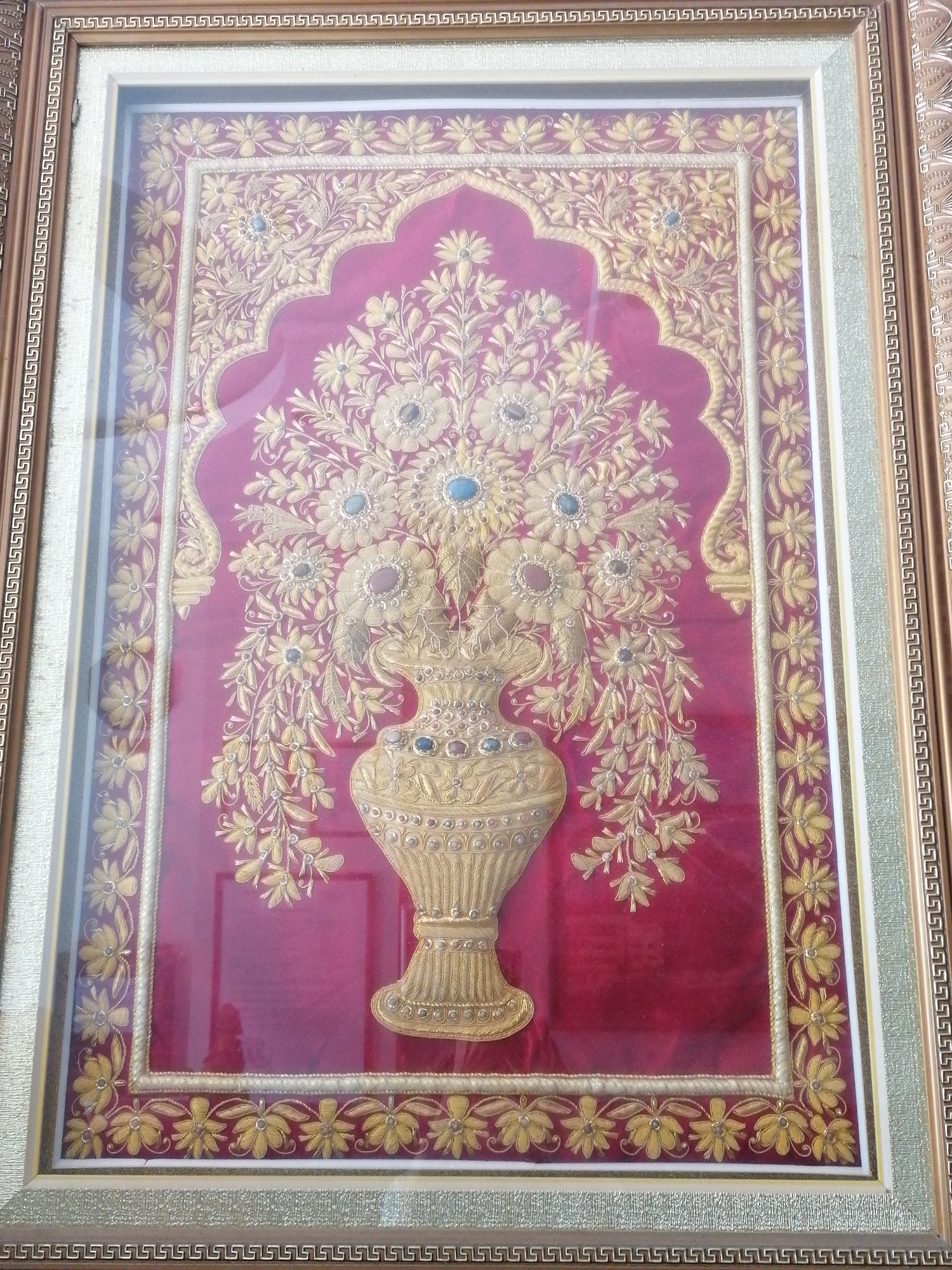 Framed artworks displayed in Nha Trang include floral textile, coastal painting