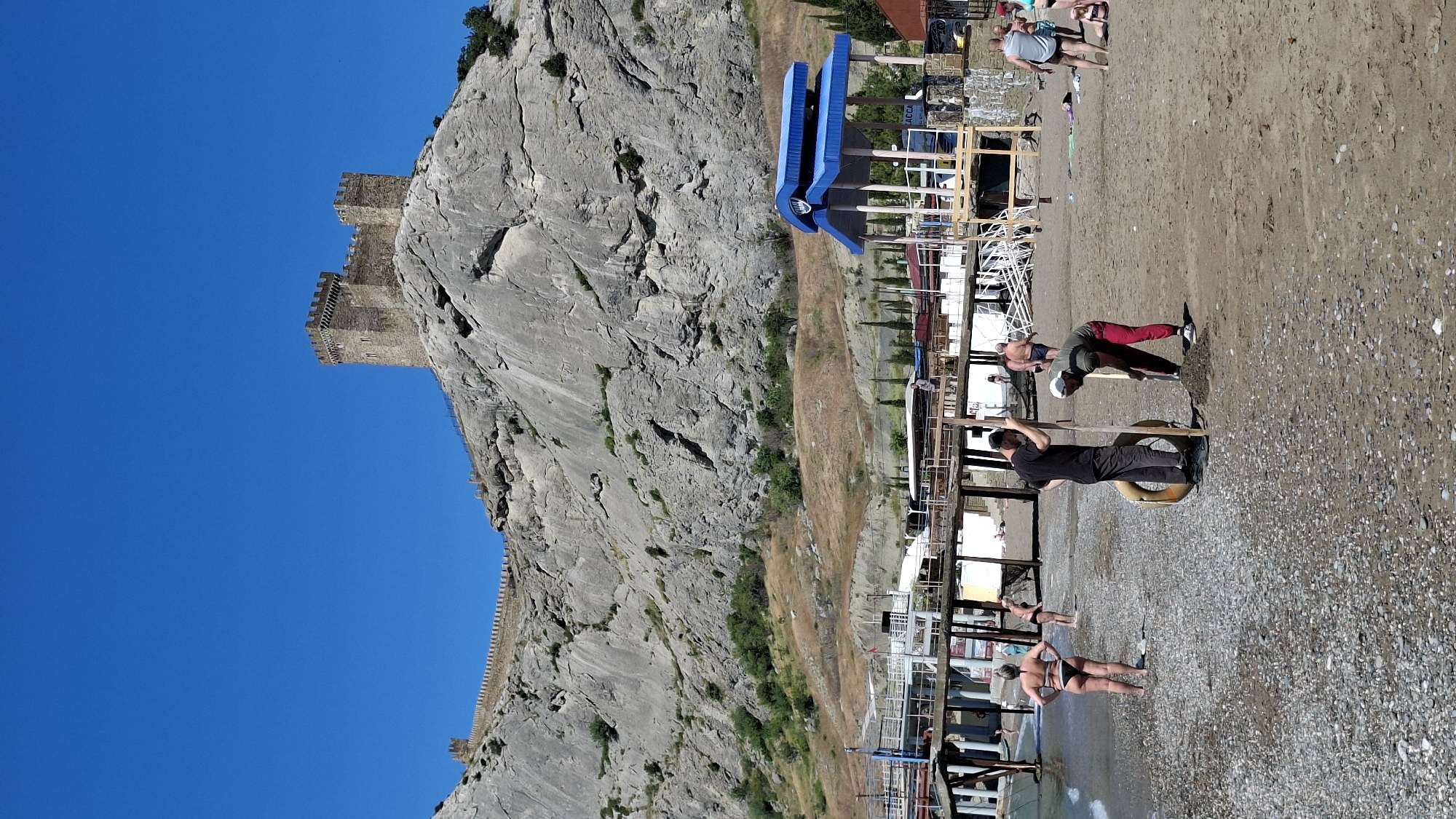 Children play at sunny coastal playground near historic castle