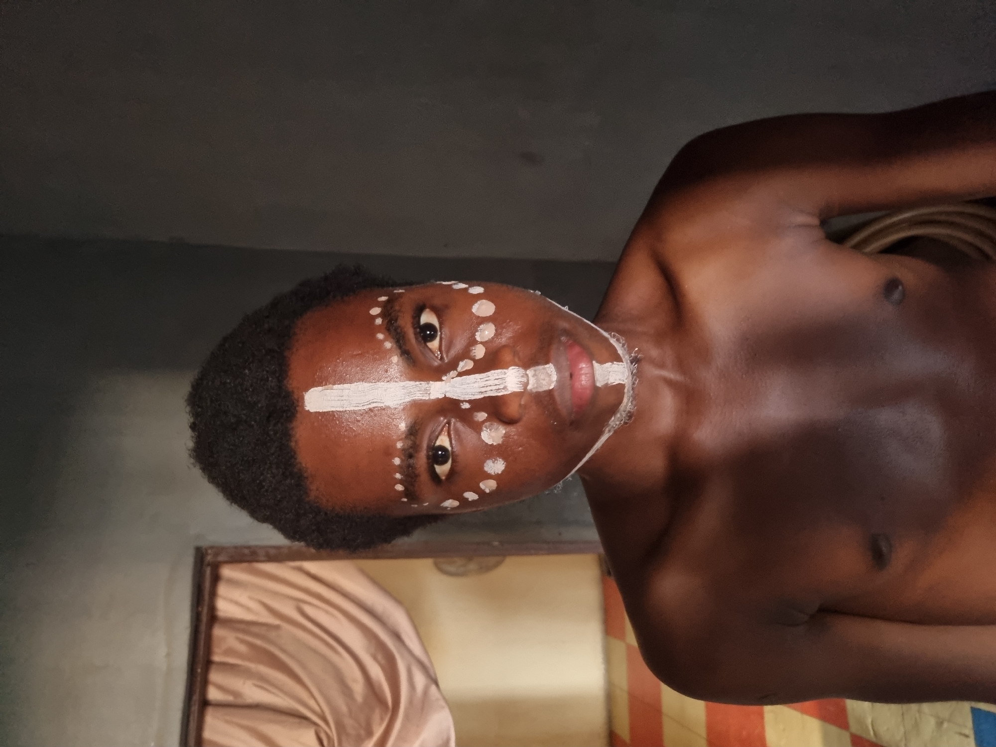 Traditional face paint application documented in Onitsha, Nigeria