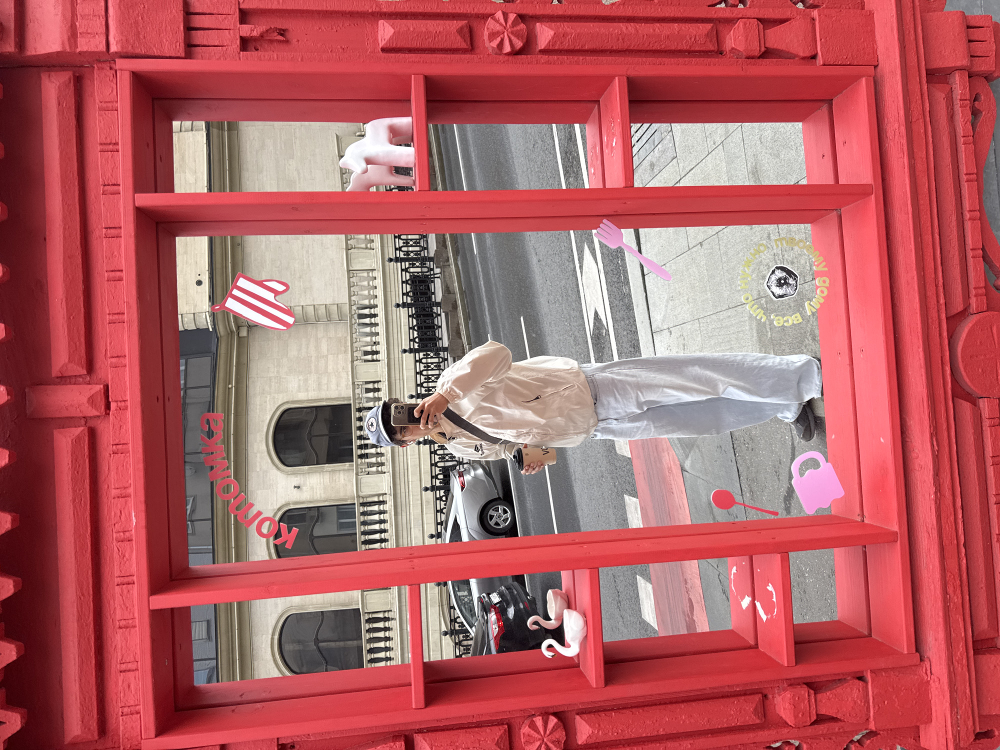Young person takes selfie behind ornate red frame in Moscow