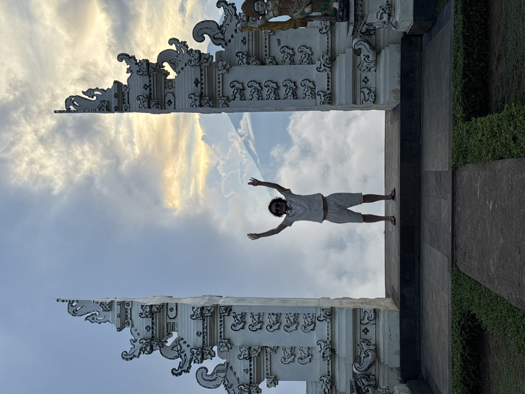 Man poses at traditional Balinese gate in Tista