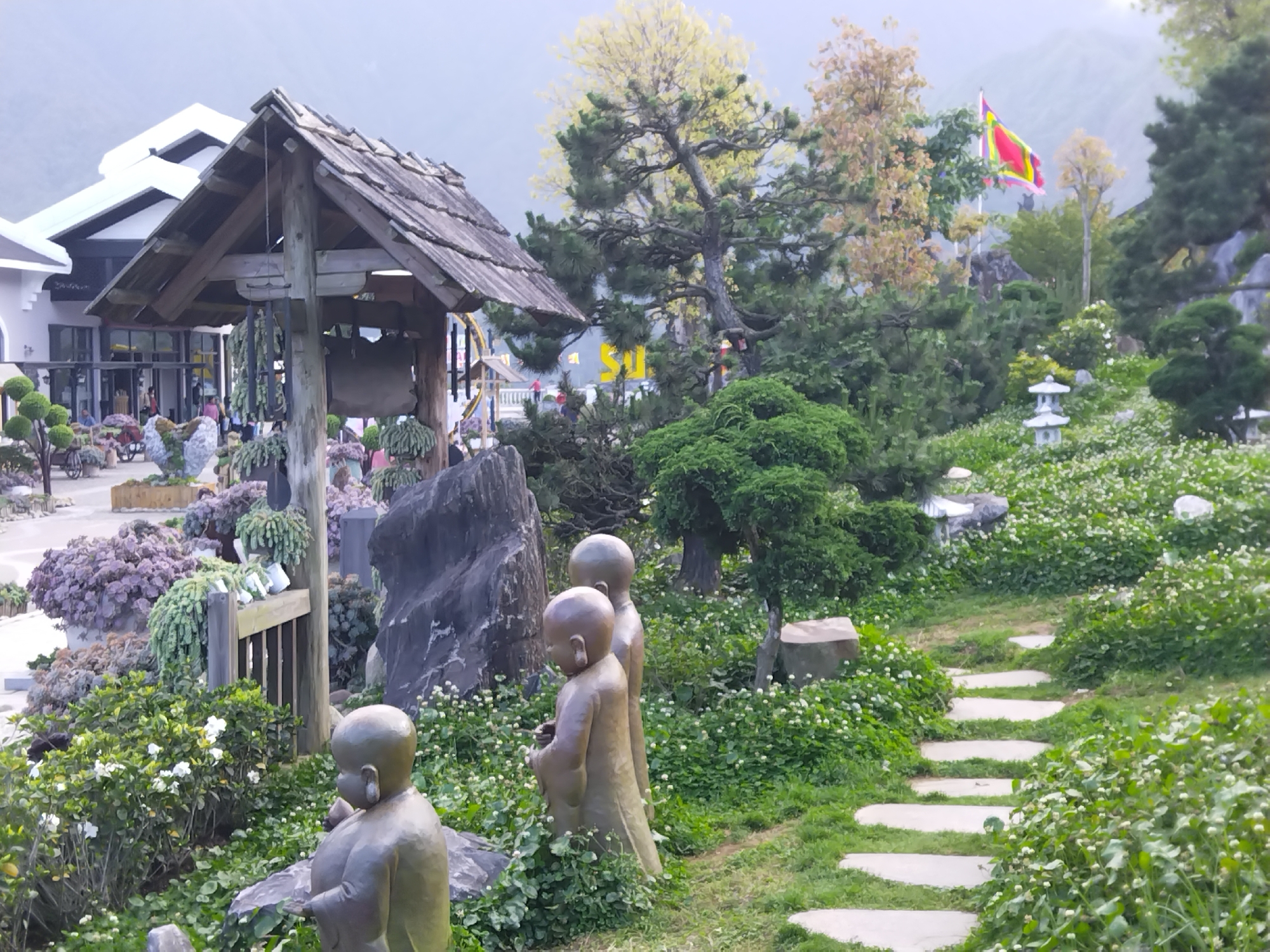Tourist documents ornamental garden with monk statues in Sa Pa