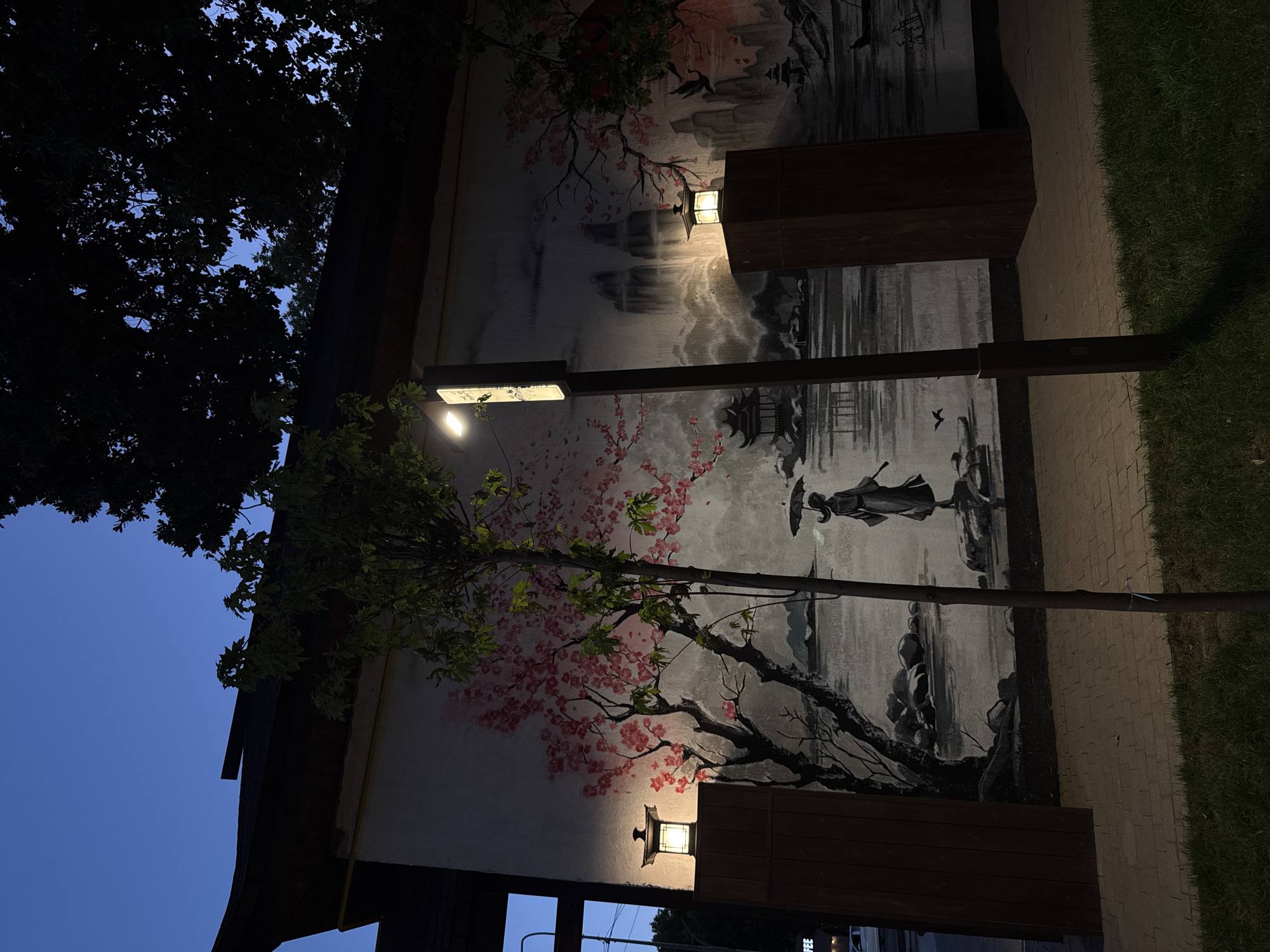East Asian-style mural on a Shymkent building wall at dusk