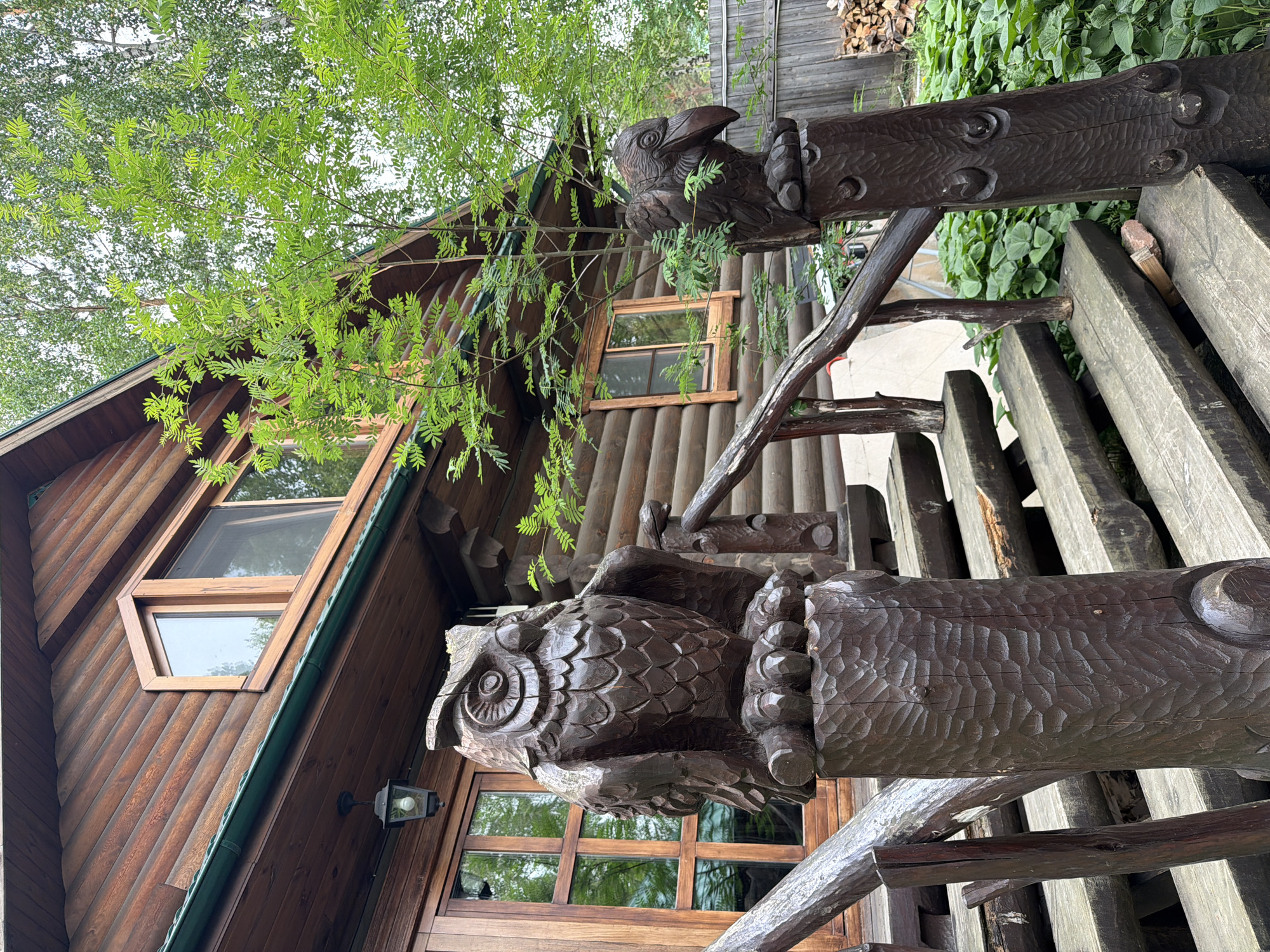 Rustic woodland homestead in Sukhaya, Russia, with carvings and blooms