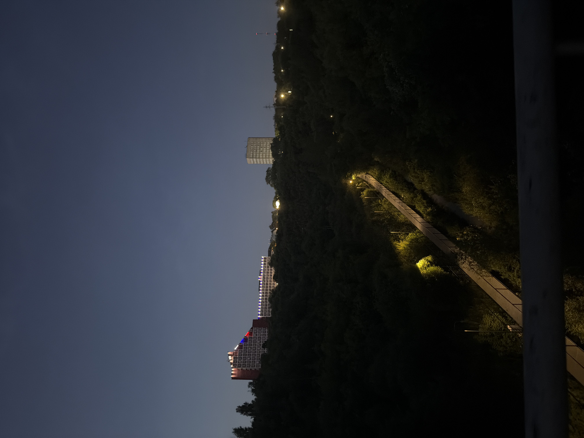 Evening walk along a tree-lined pedestrian bridge in Perm