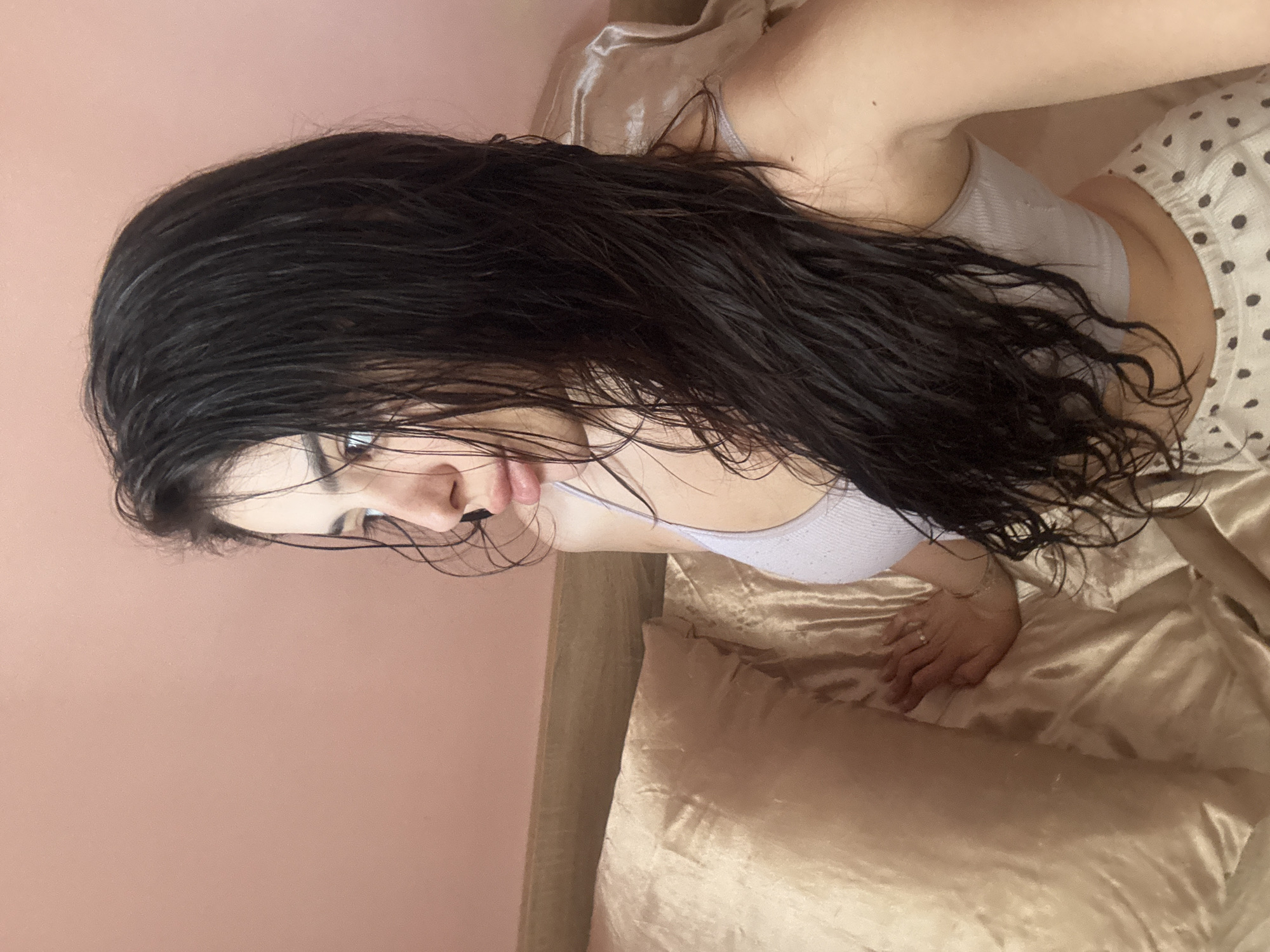 Woman with wet hair rests on bed in Plovdiv