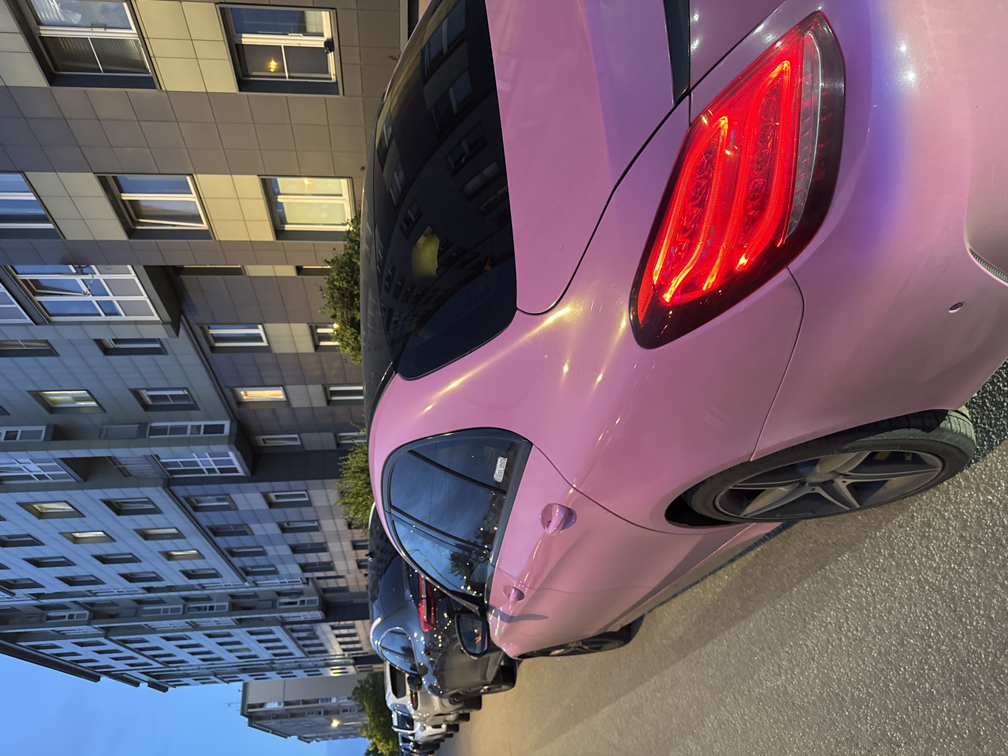 Pink car parked in Shushary as dusk settles over the neighborhood