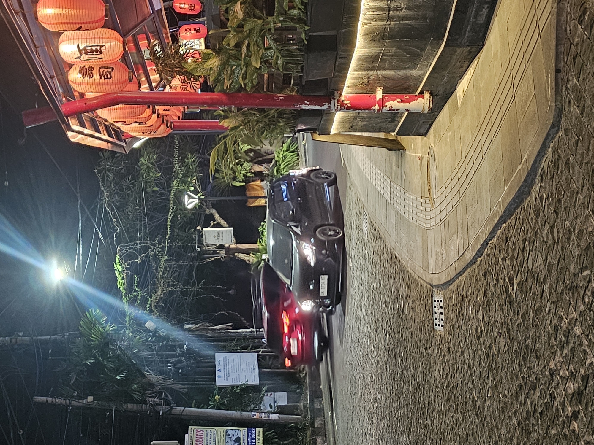 Nighttime street life documented in lantern-decorated Denpasar district