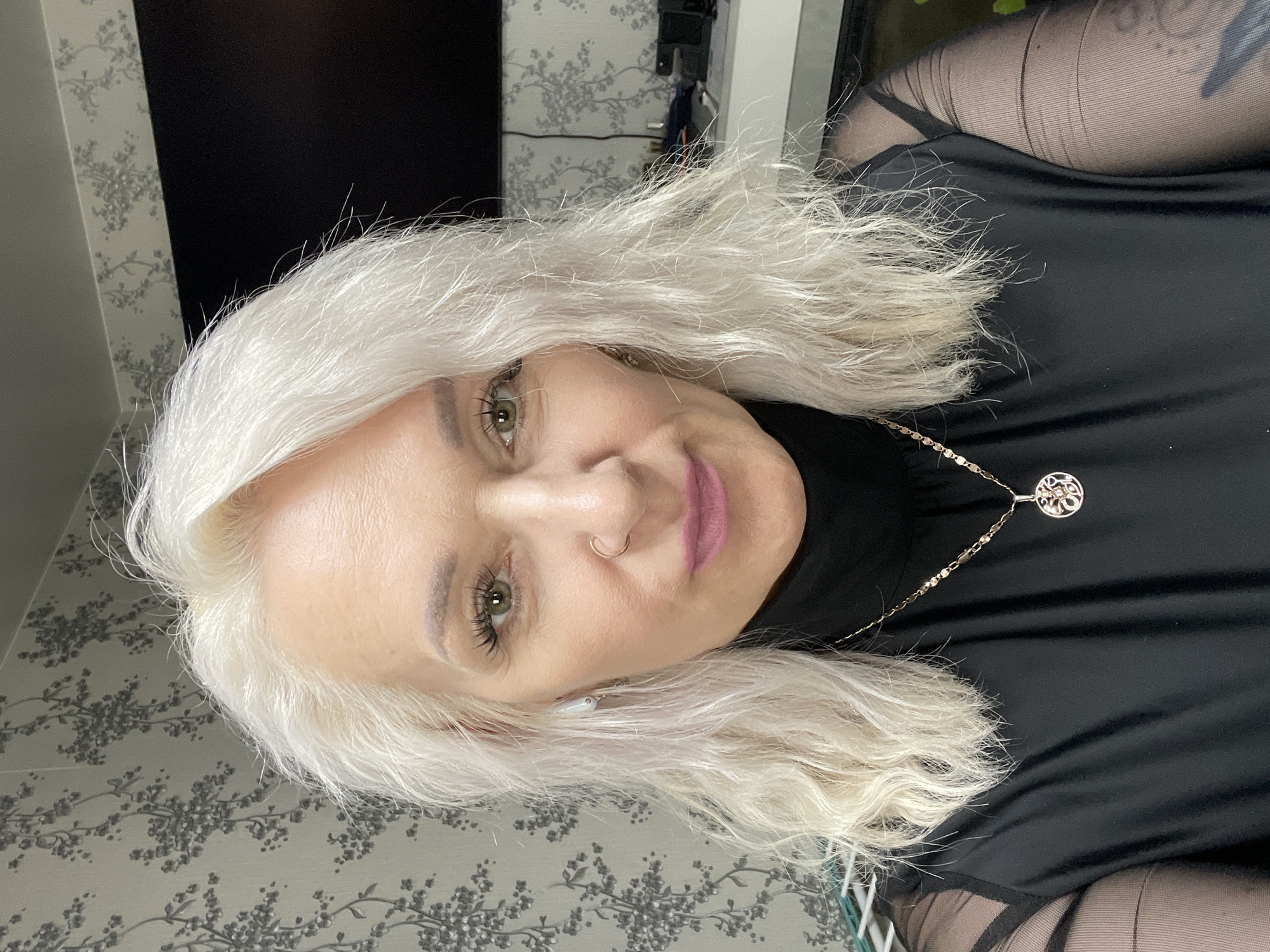 Selfie in black mesh-sleeve top with gold chain accessory