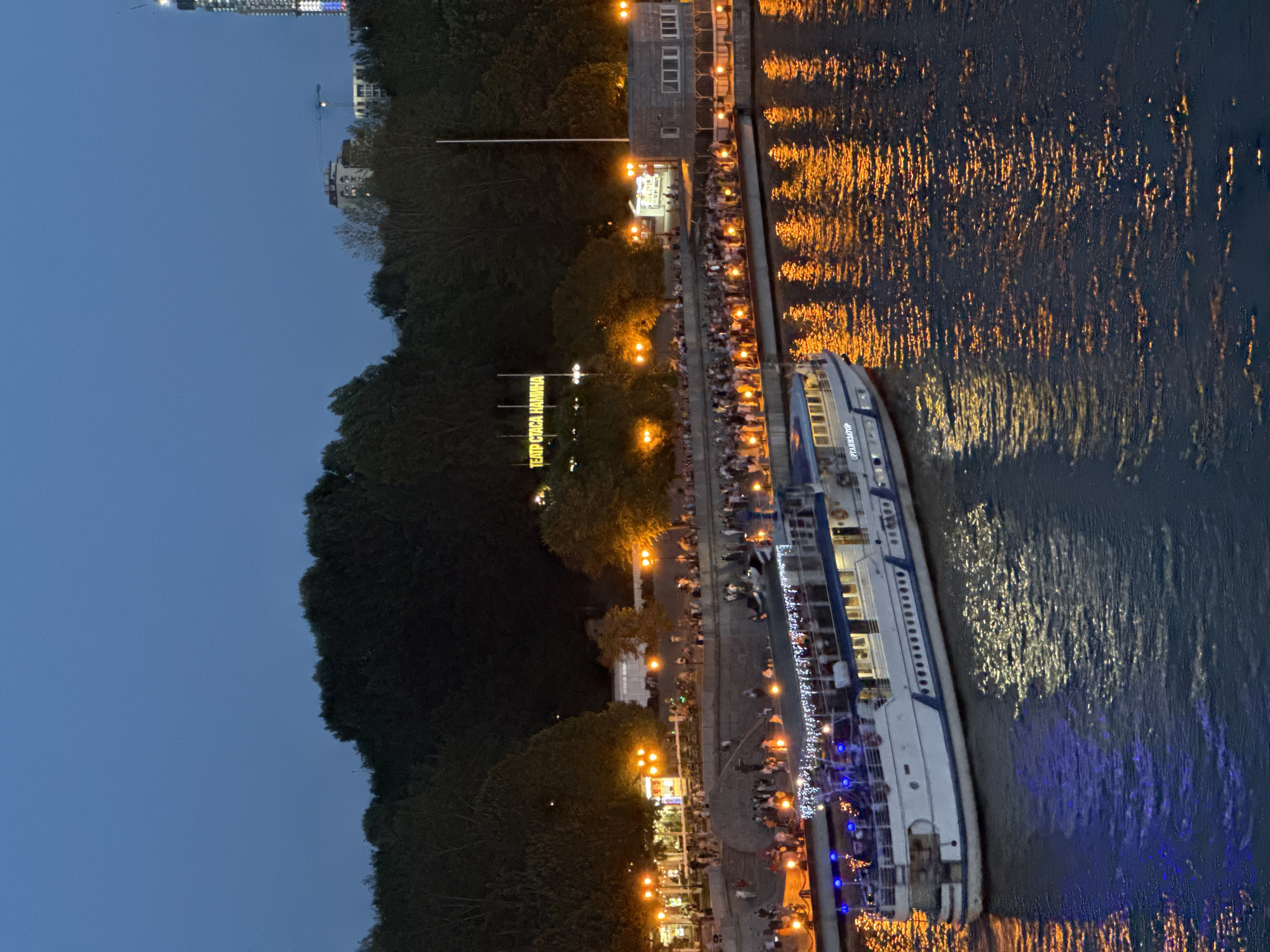 Moscow riverfront at night, lit by boat and embankment lights.