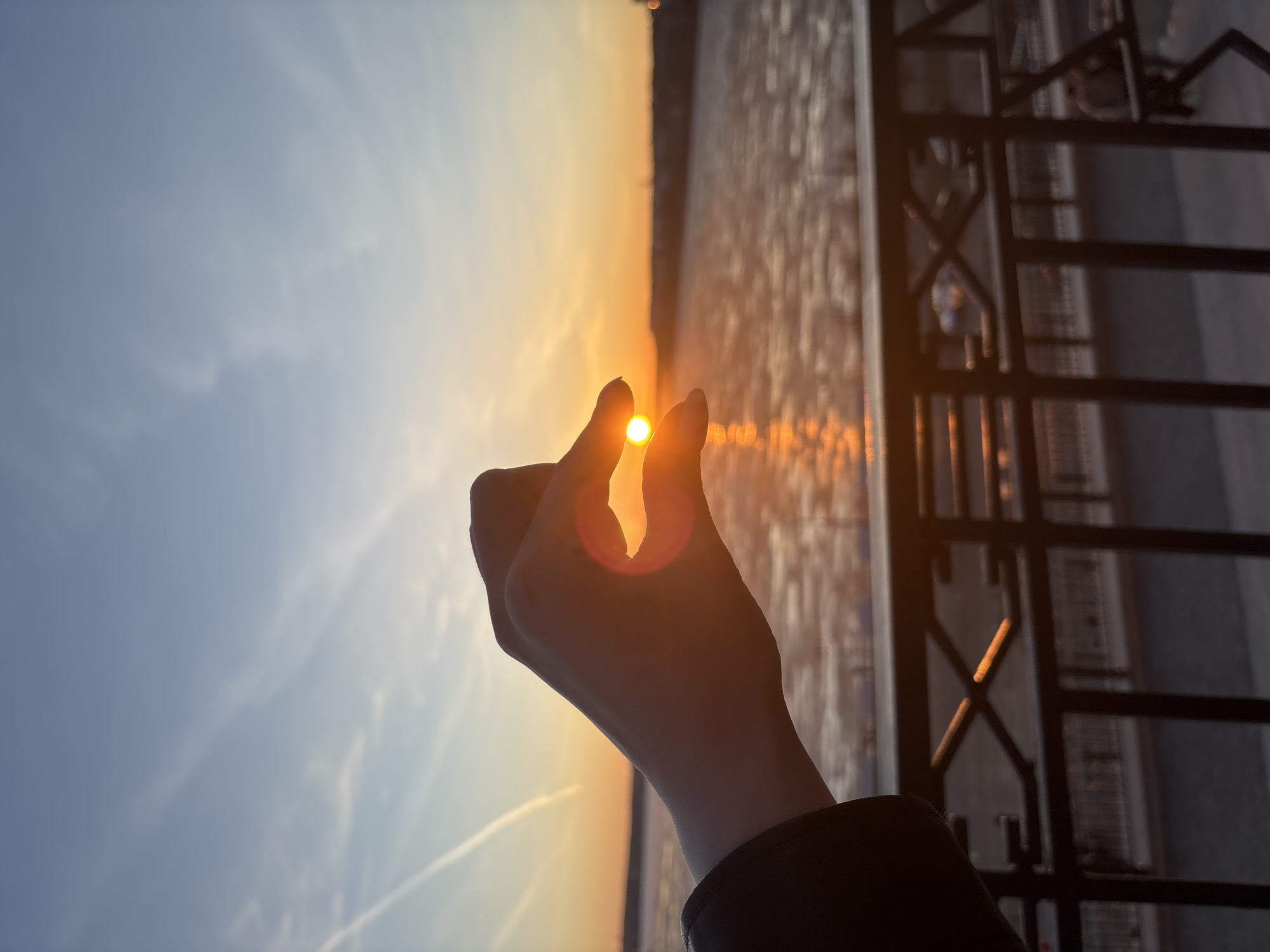 Woman takes sunset selfies along Izhevsk waterfront embankment