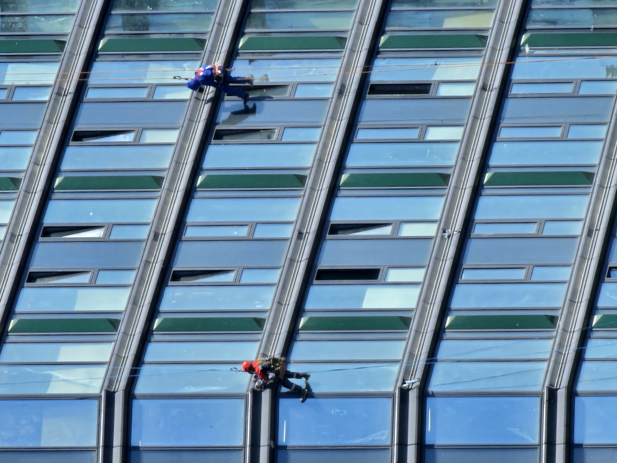Window cleaners work Moscow skyscrapers during midday operations