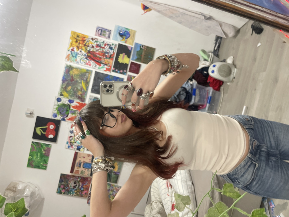Young woman takes mirror selfies in decorated bedroom in Ra'anana