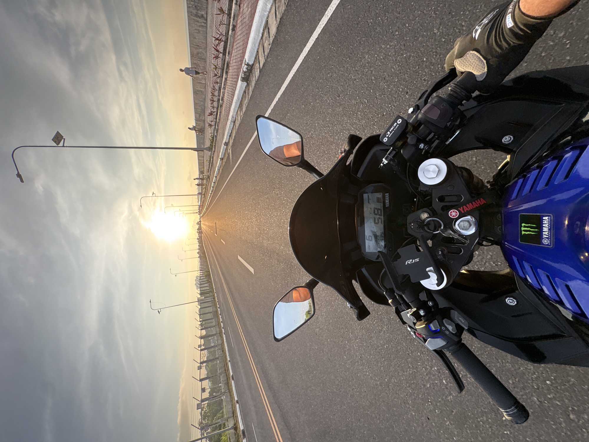 Motorcyclist rides Yamaha on Davao City highway at sunset