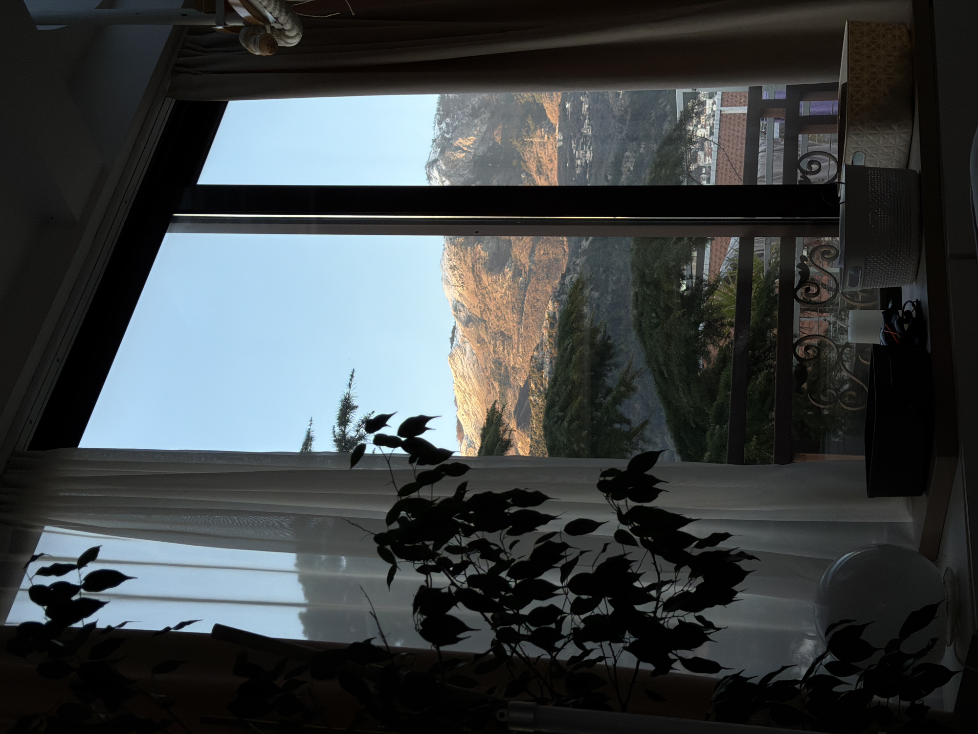 Indoor window view captures Montenegro mountain landscape in Budva