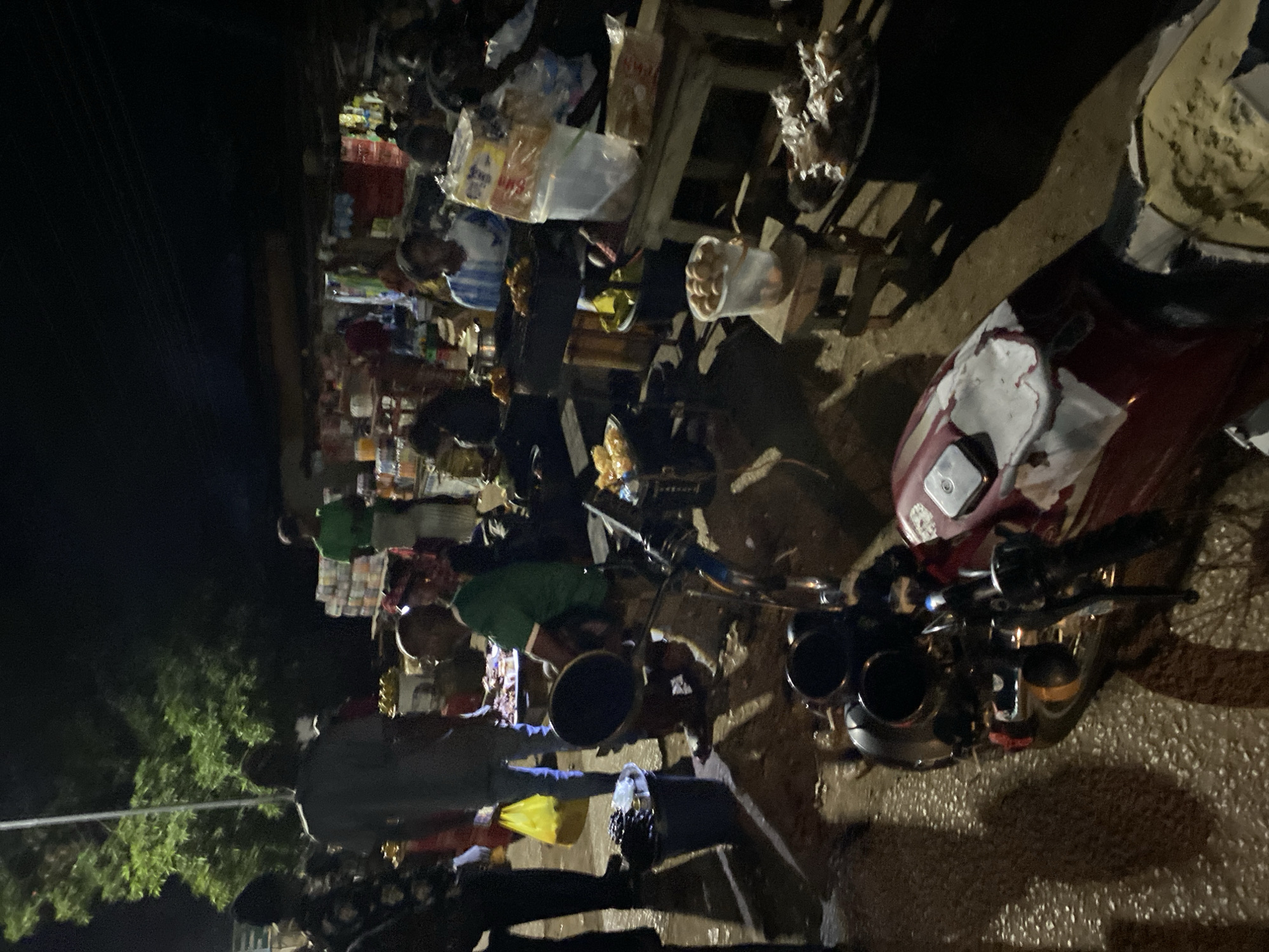 Nighttime street market bustles with vendors in Bukuru, Nigeria