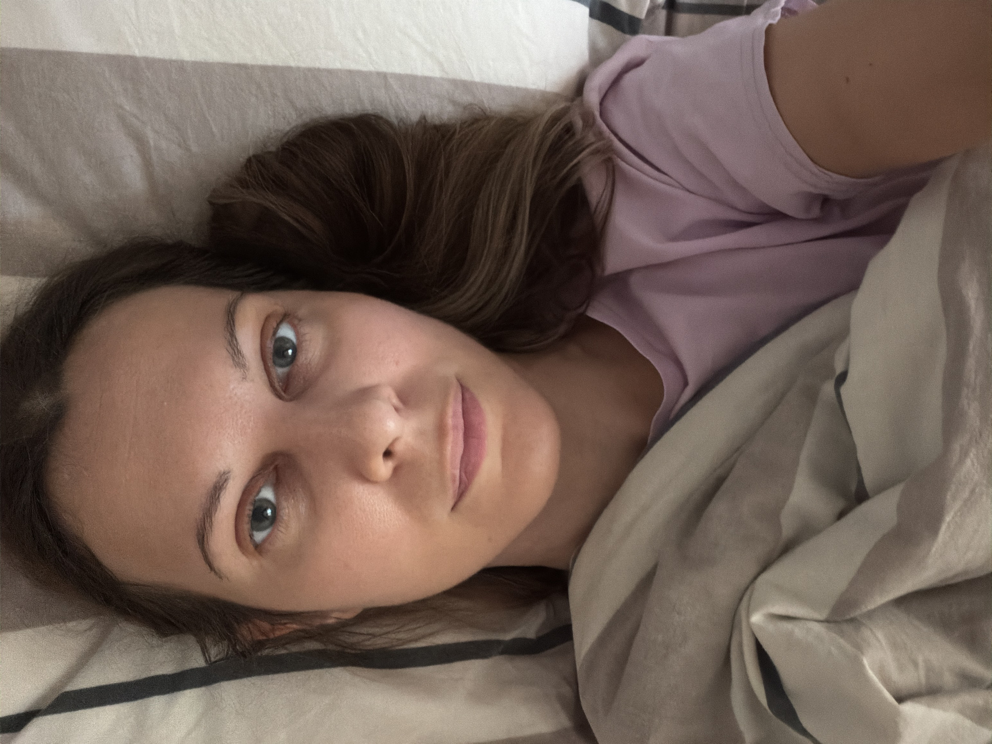 Sphynx cat and owner share a slow morning in bed