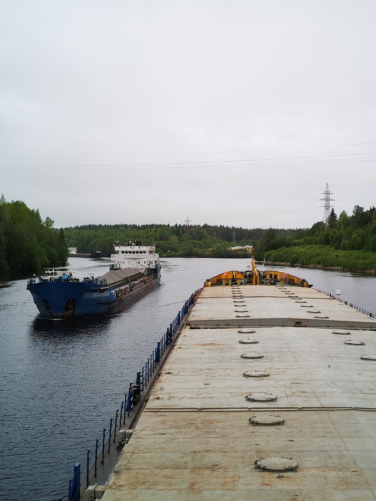Cargo barges navigate Russian waterway carrying gravel and sand
