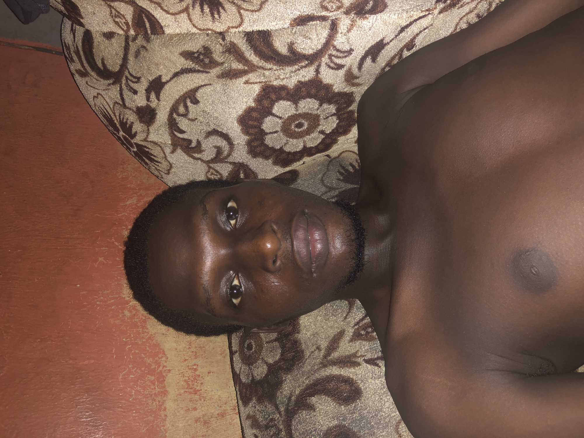 Man relaxes on couch with phone during evening hours