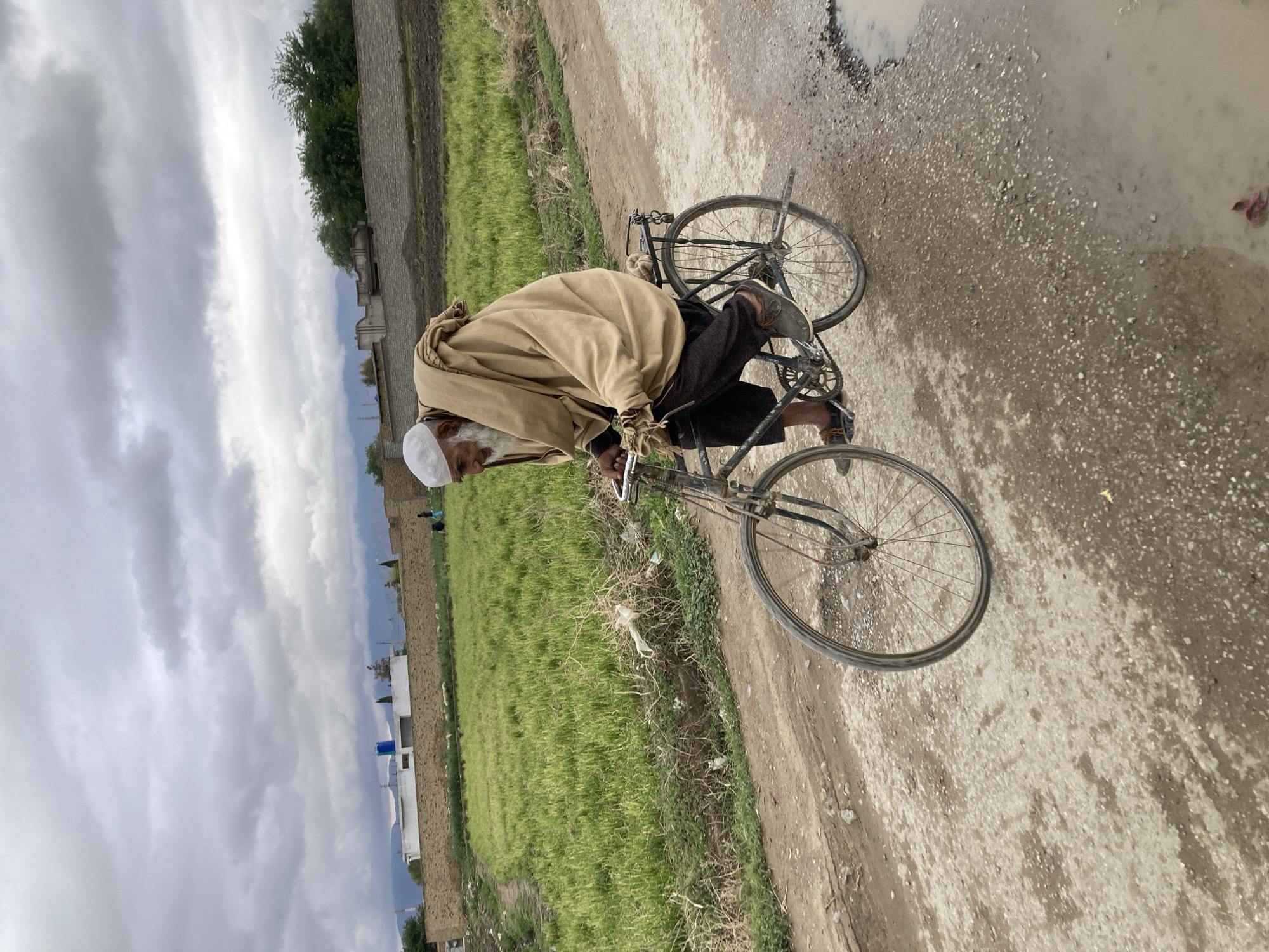 Elderly cyclist spotted on rural dirt road in Quetta