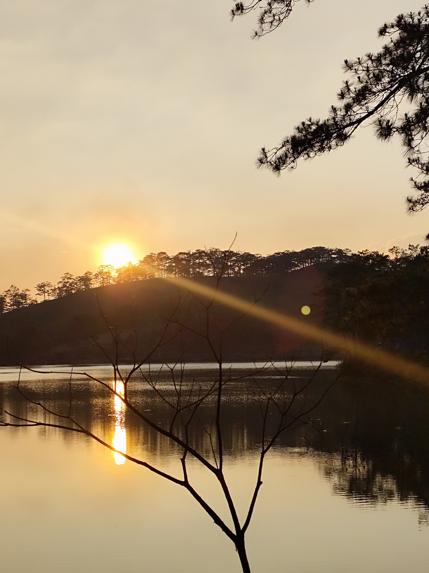 Peaceful sunset captured at Vietnamese lake with golden reflections