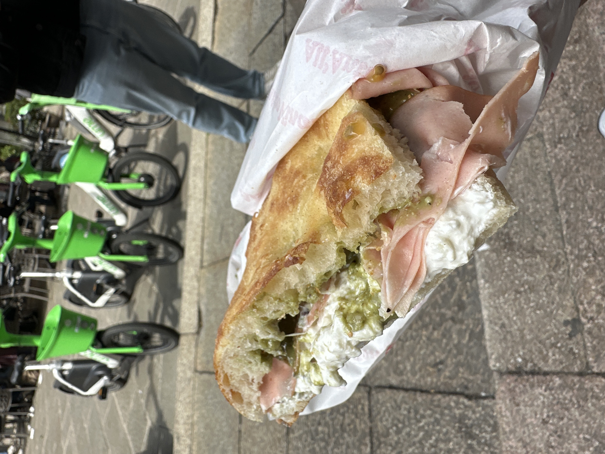 Person enjoys sandwich lunch on Milan streets