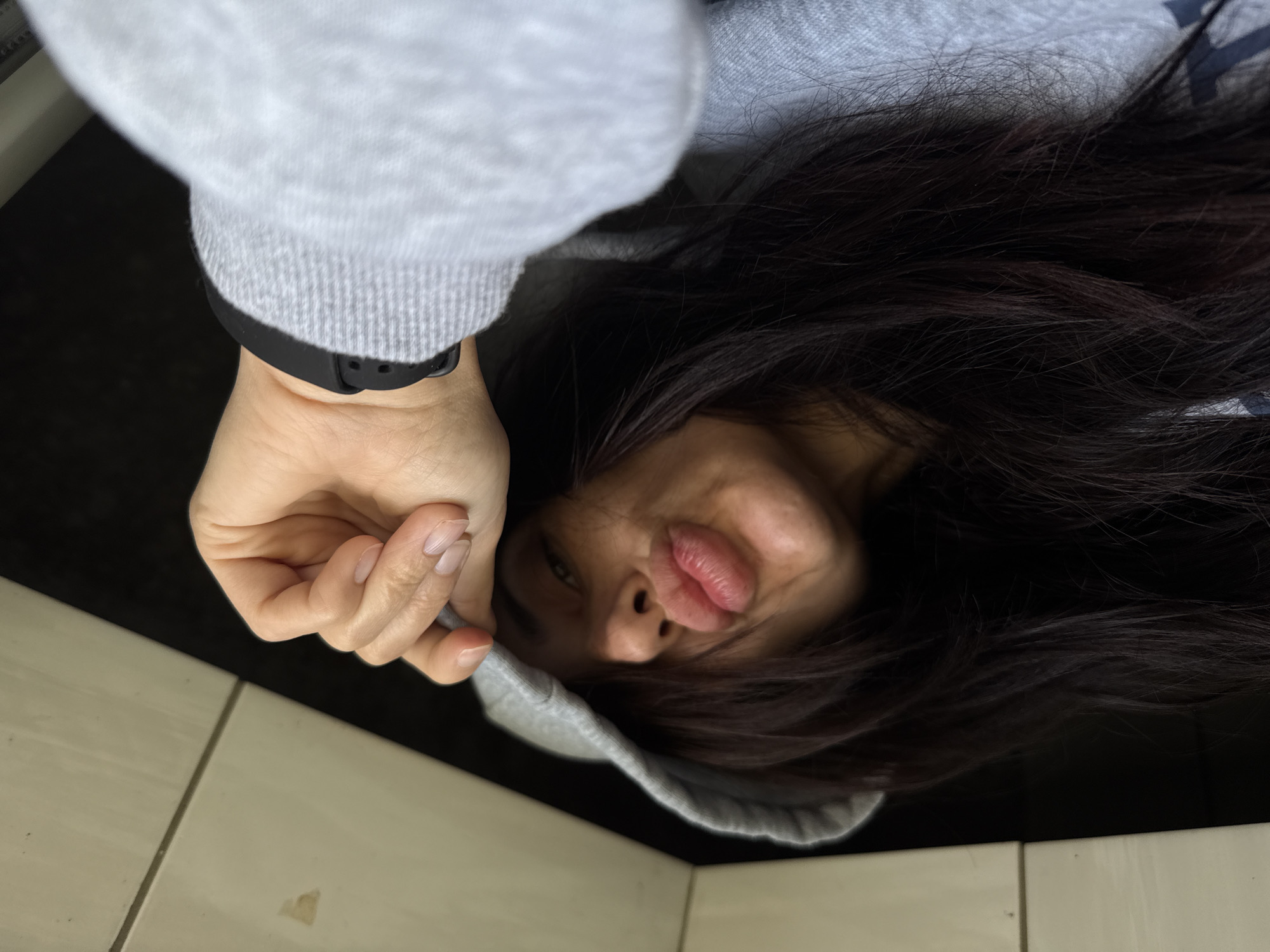 Woman in gray hoodie photographed on floor in Bulgaria