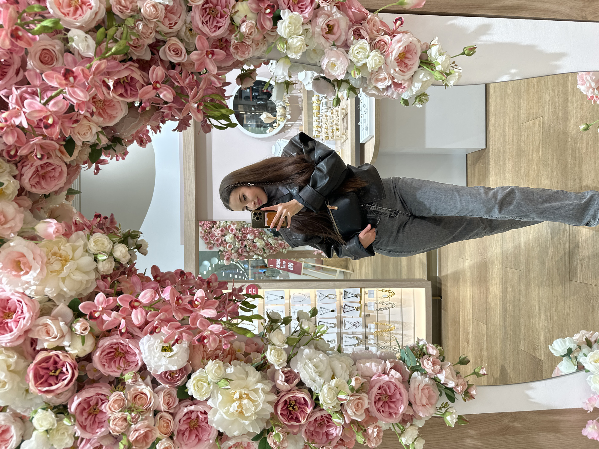 Woman takes selfie in flower-adorned mirror in Yekaterinburg