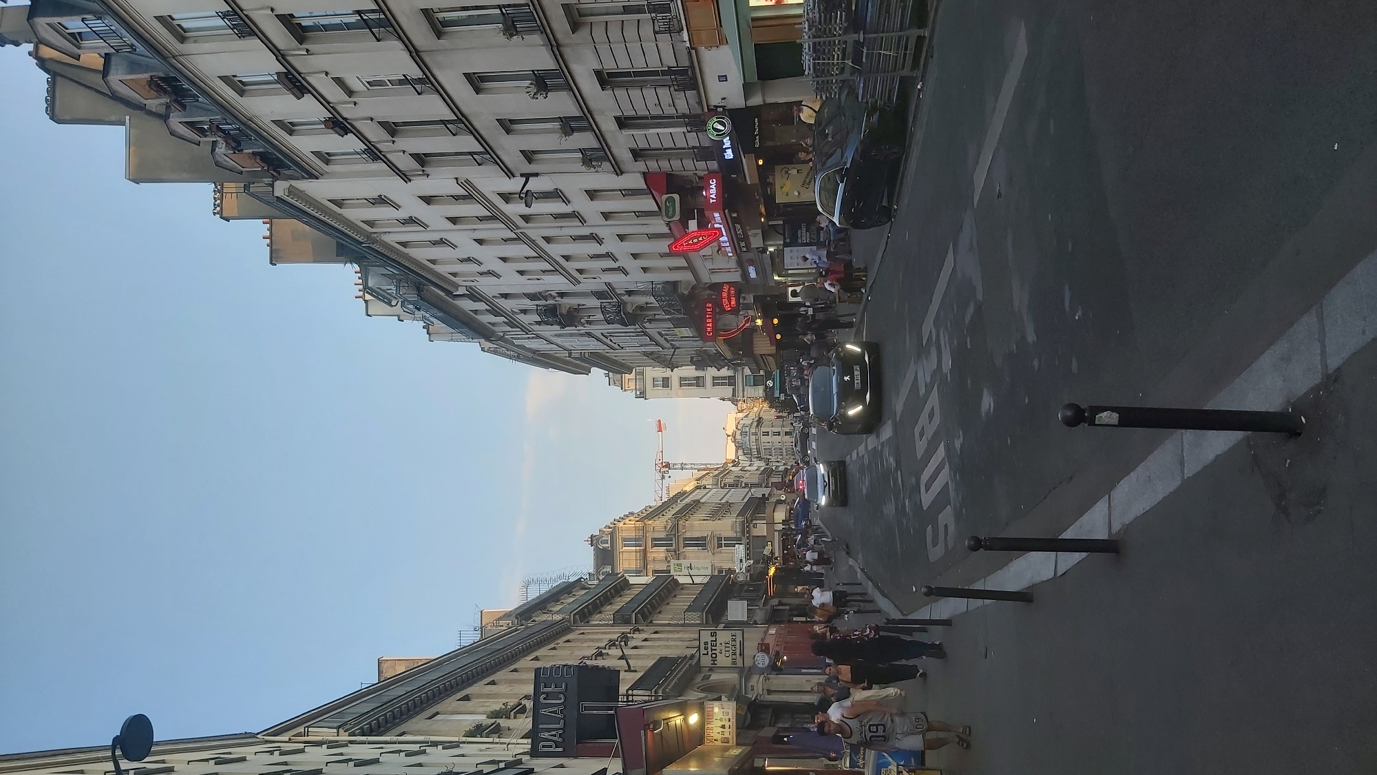 Evening street life across a busy Paris neighborhood