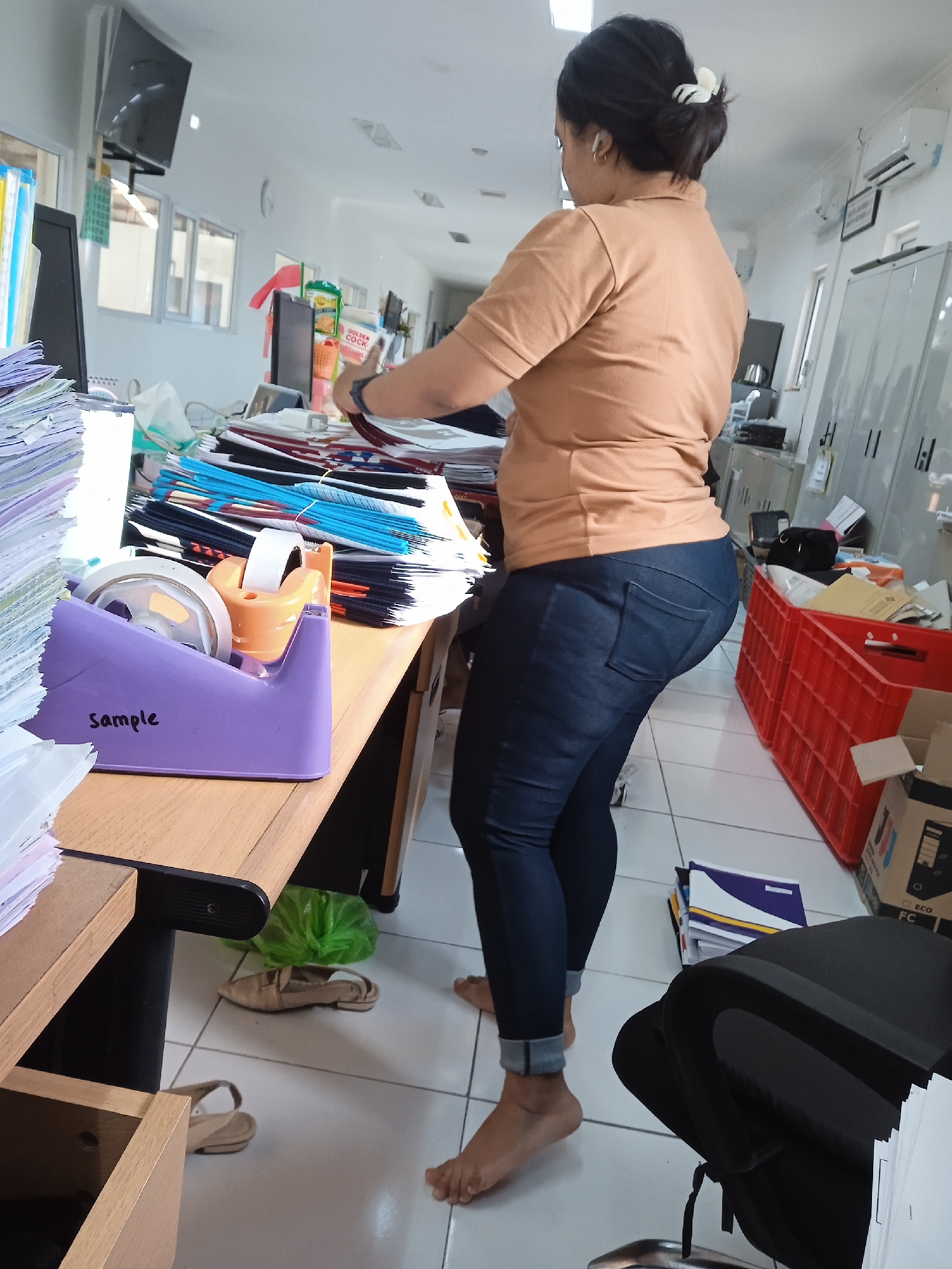 Woman observed in cluttered office workspace in Semarang