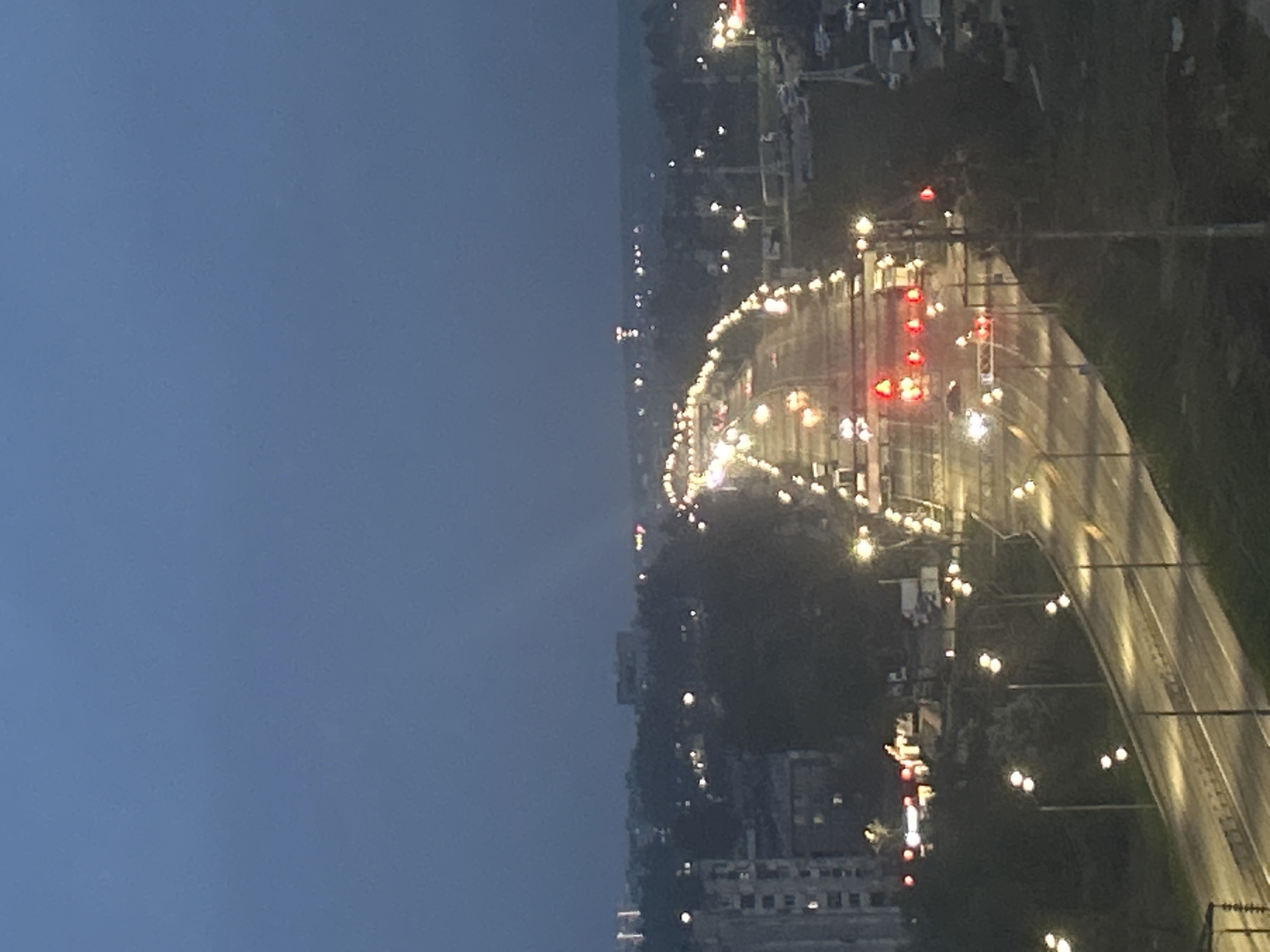 Aerial nighttime view captures illuminated curved city road