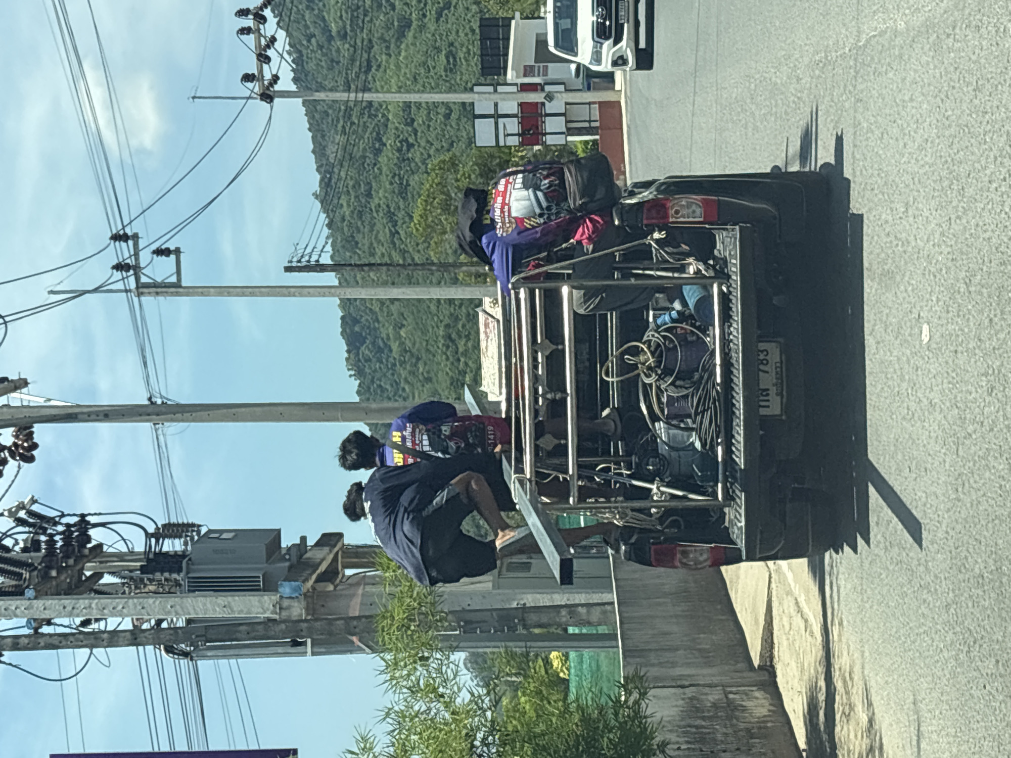 Pickup truck carries three passengers through Choeng Thale vegetation