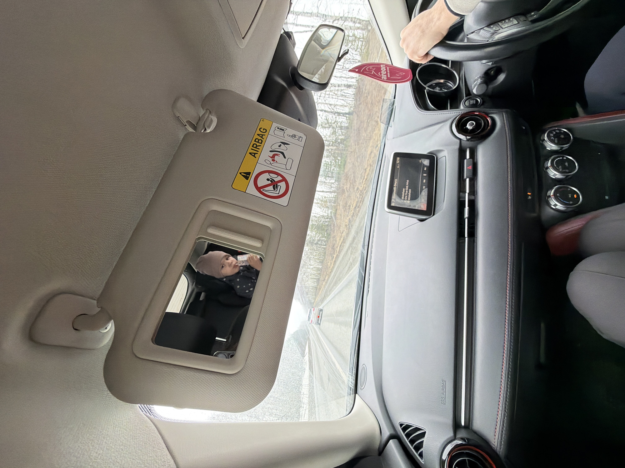 Child drinks from bottle in car seat in Kukui
