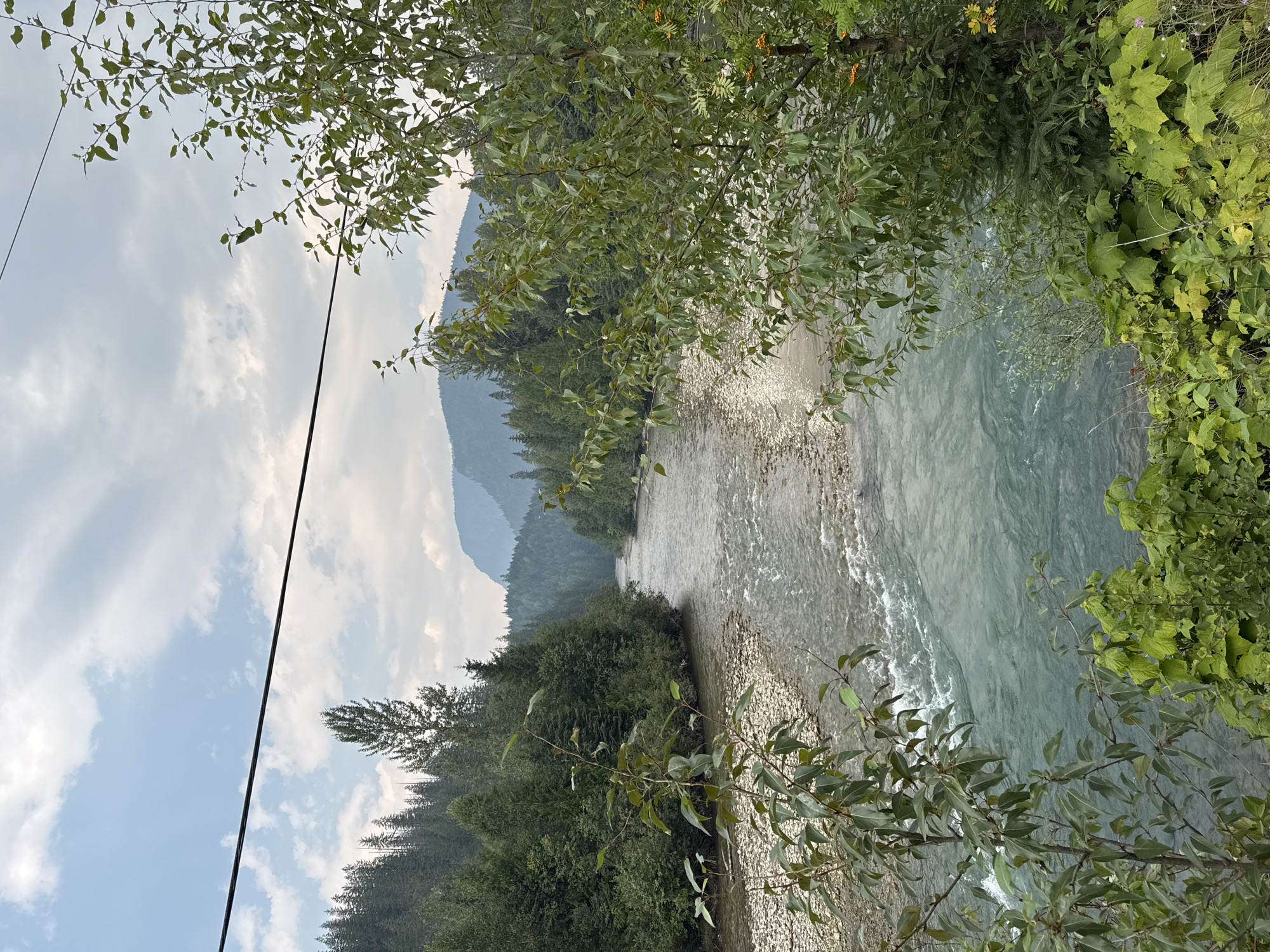 Wide river flows past rocky shores in BC's forested interior