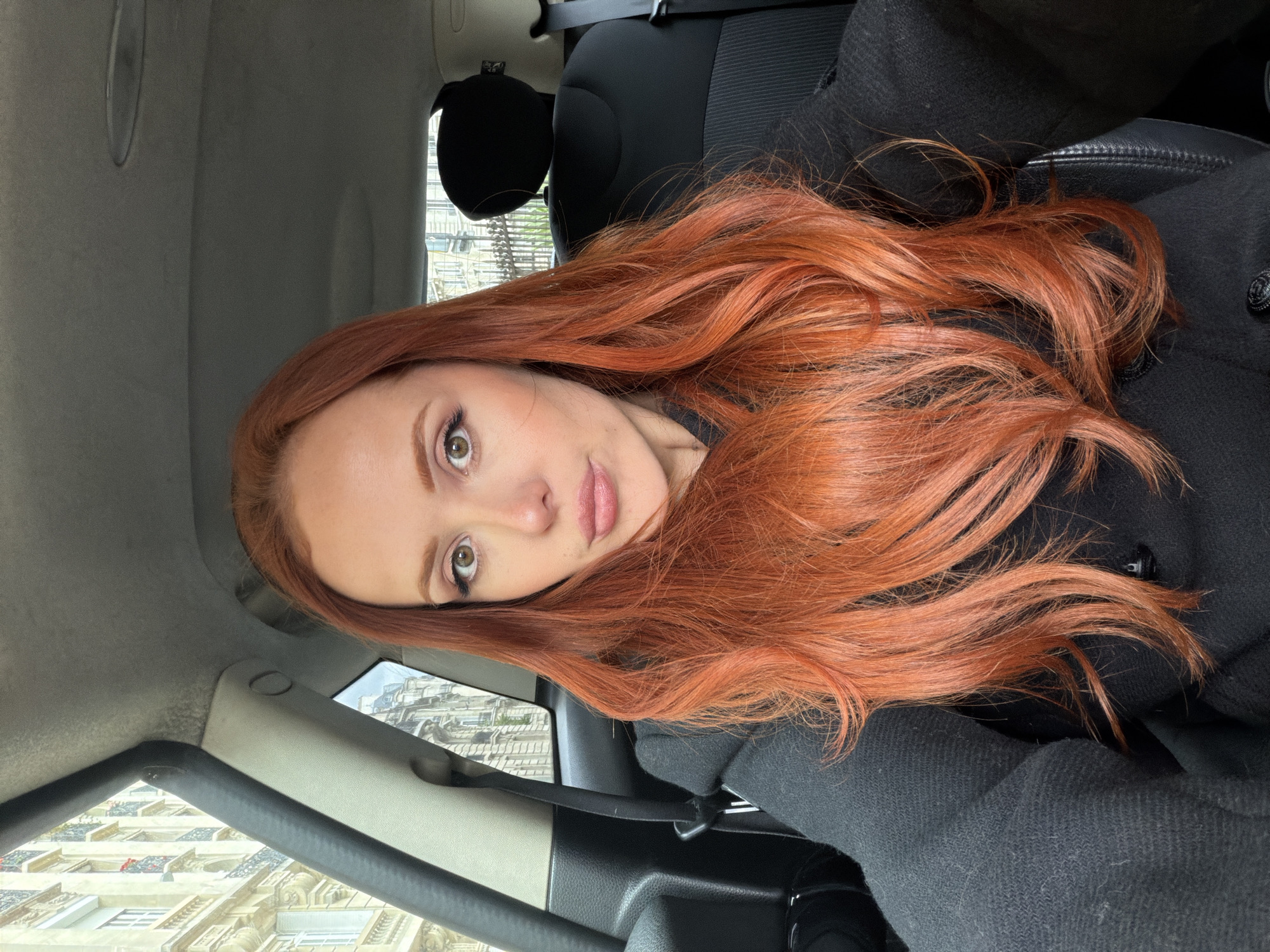 Red-haired woman in black coat spotted driving in Paris