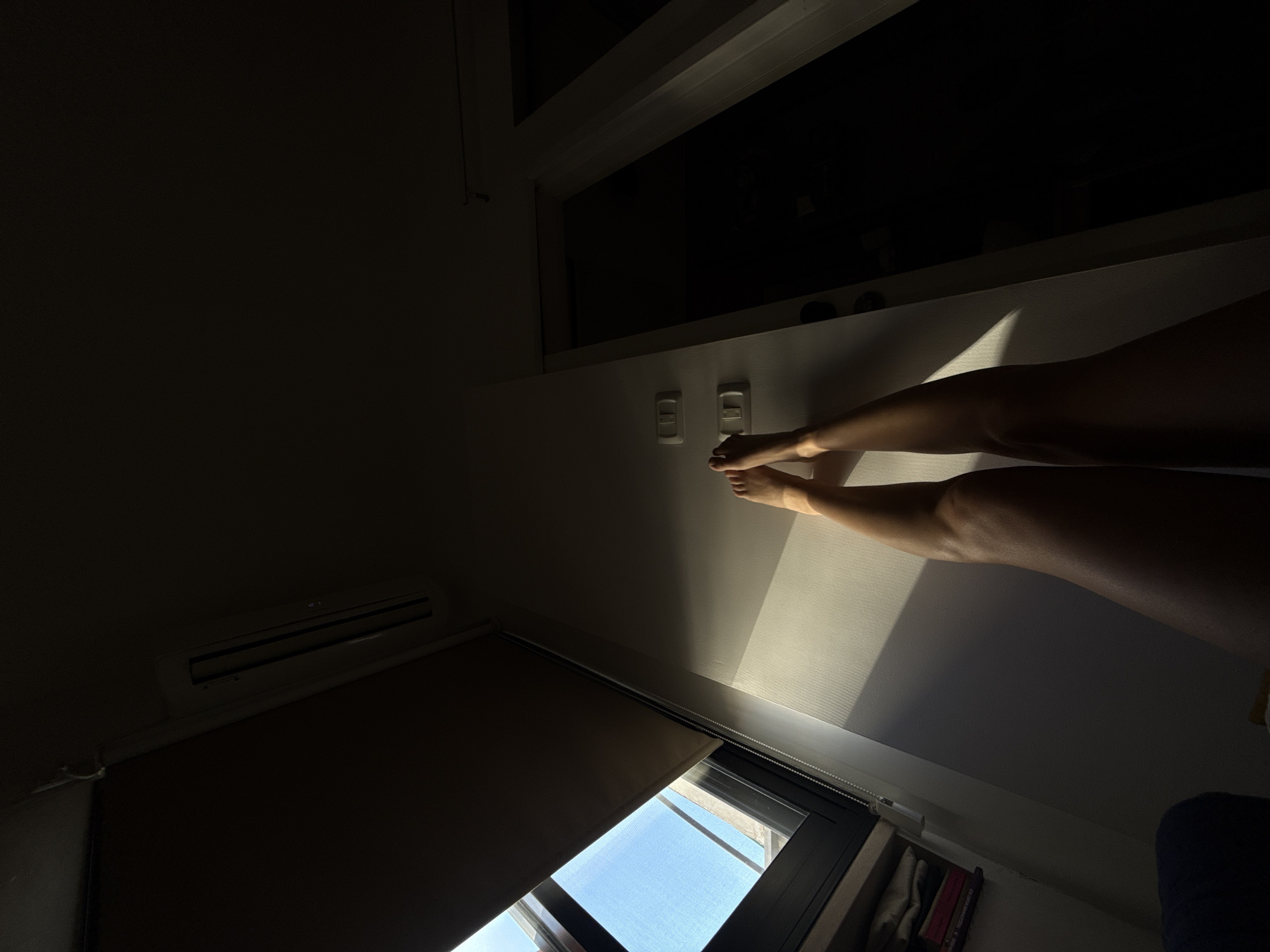 Legs up a sunlit white wall in Tel Aviv