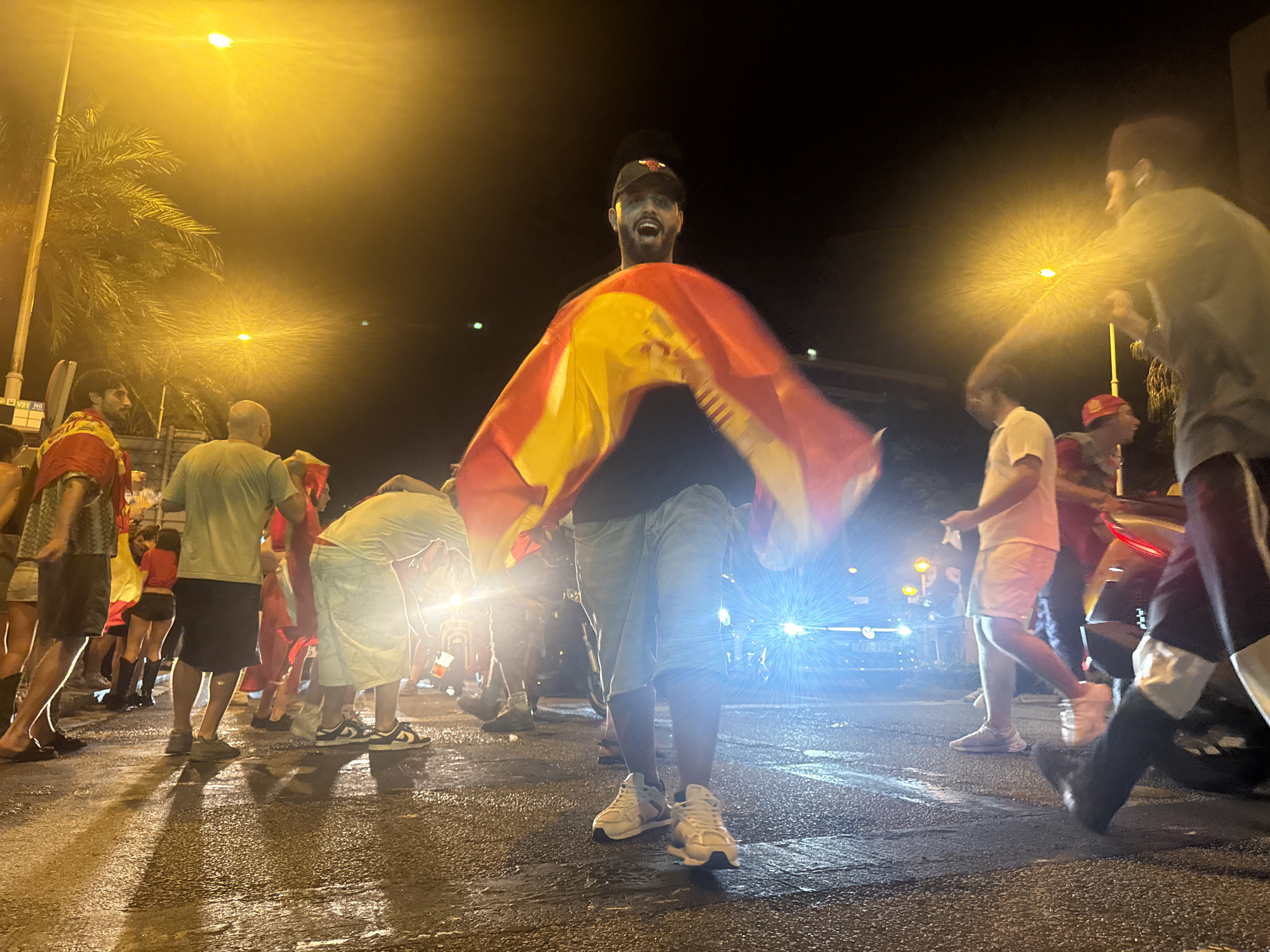 Spanish flags raised during a Barcelona street celebration at night