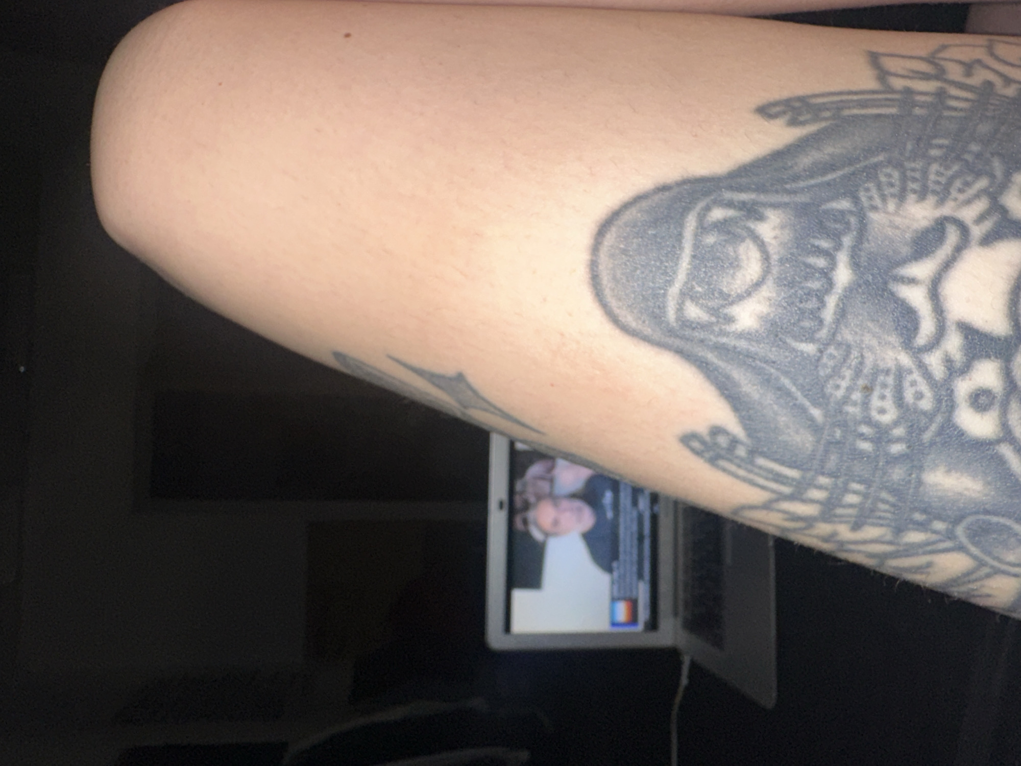 Tattooed person uses MacBook for social media in Buenos Aires