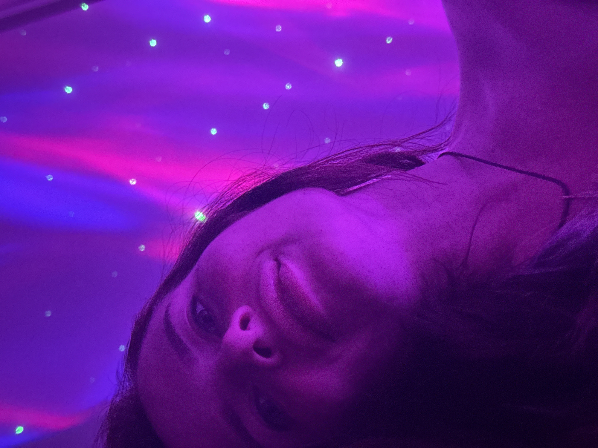 Portrait session under purple and pink atmospheric lighting indoors