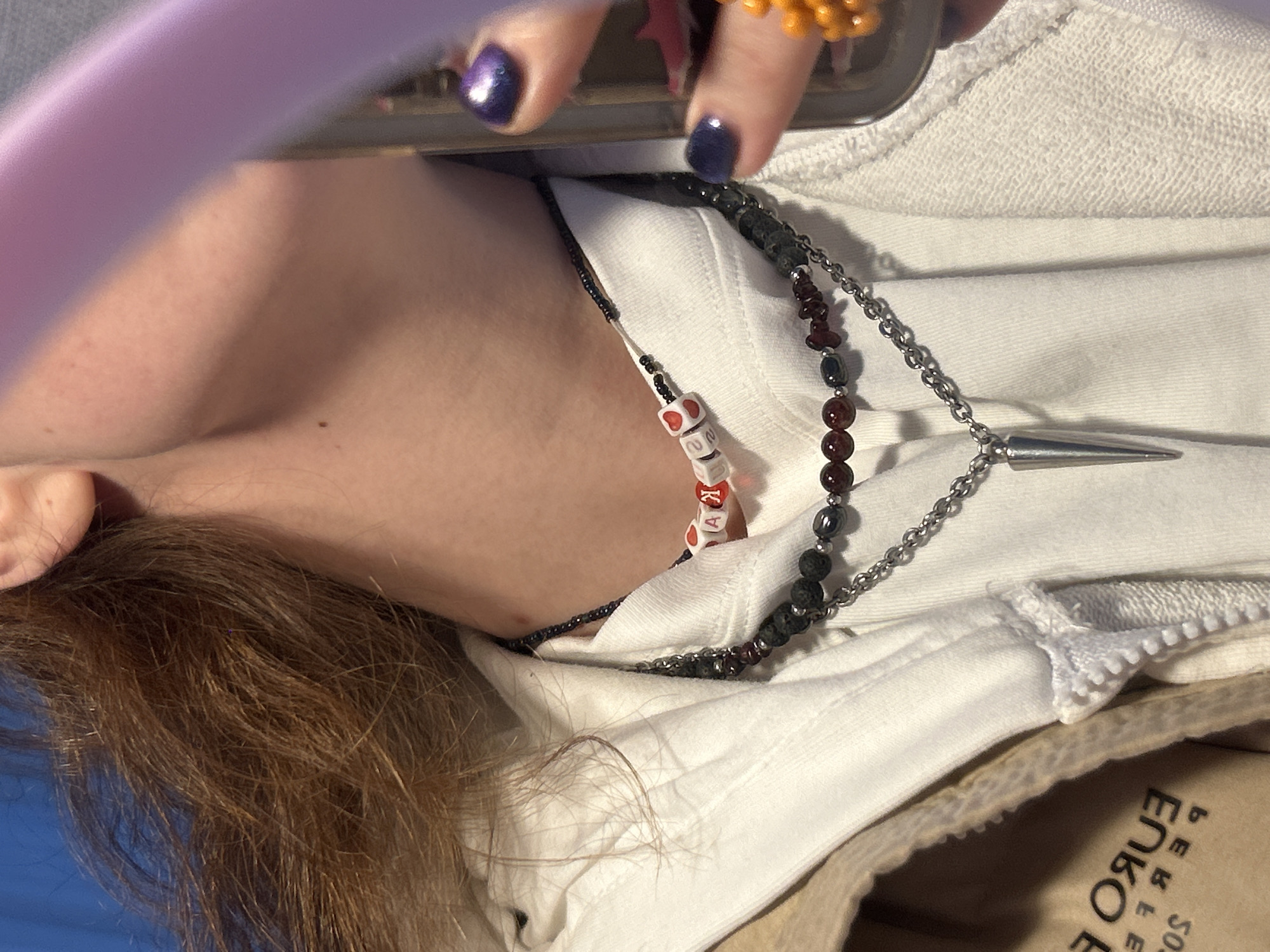 Person photographed wearing white hoodie, multiple necklaces in Krasnoyarsk
