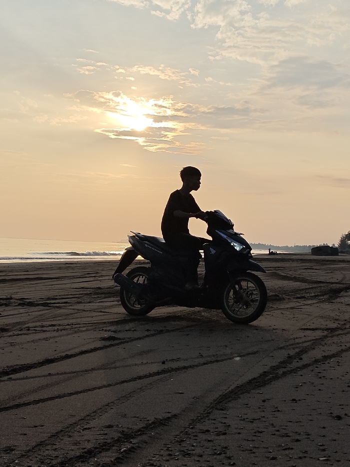 Beach sunrise witnessed by multiple visitors in Indonesia