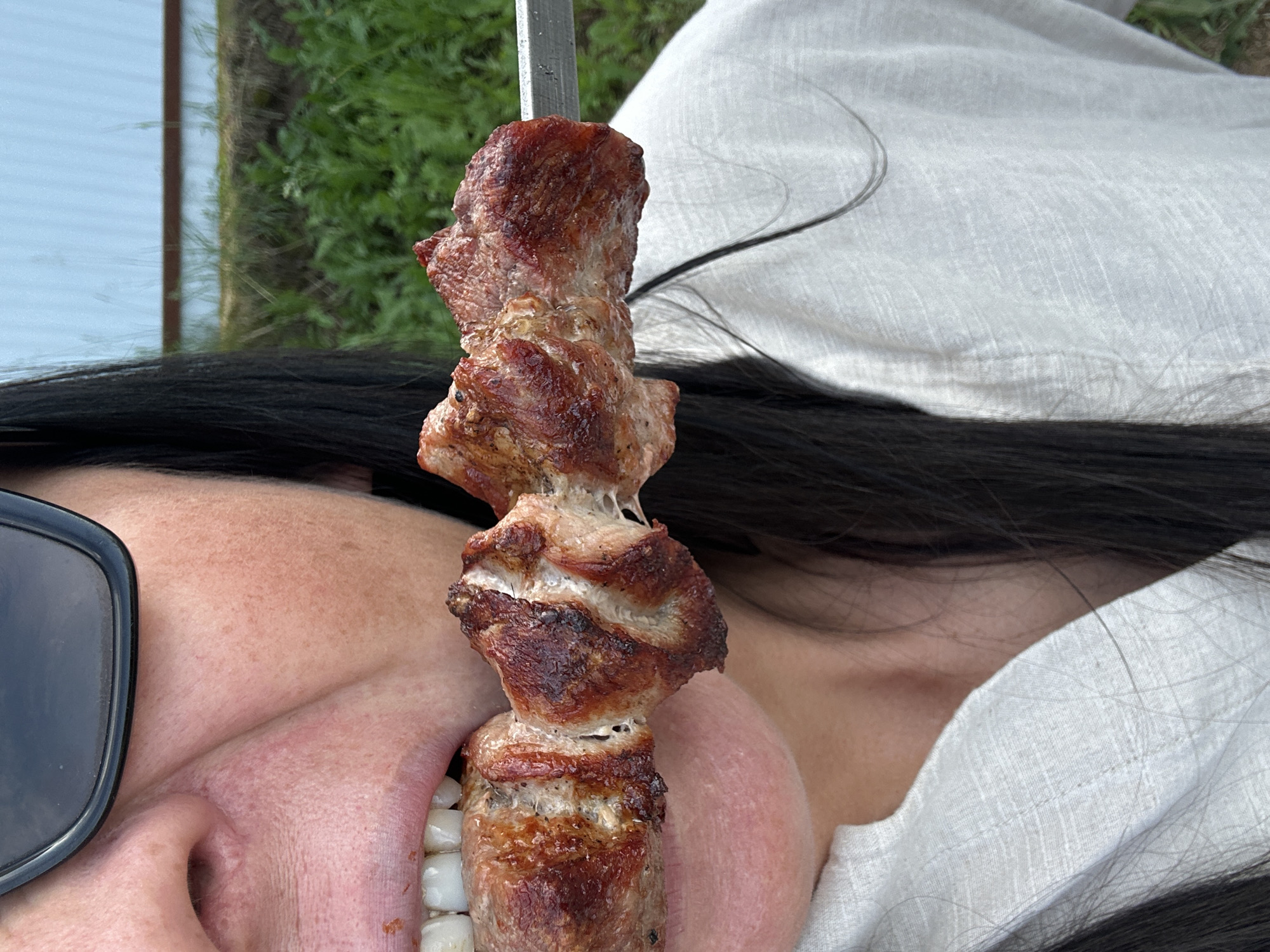 Friends gather for backyard barbecue with grilled skewers