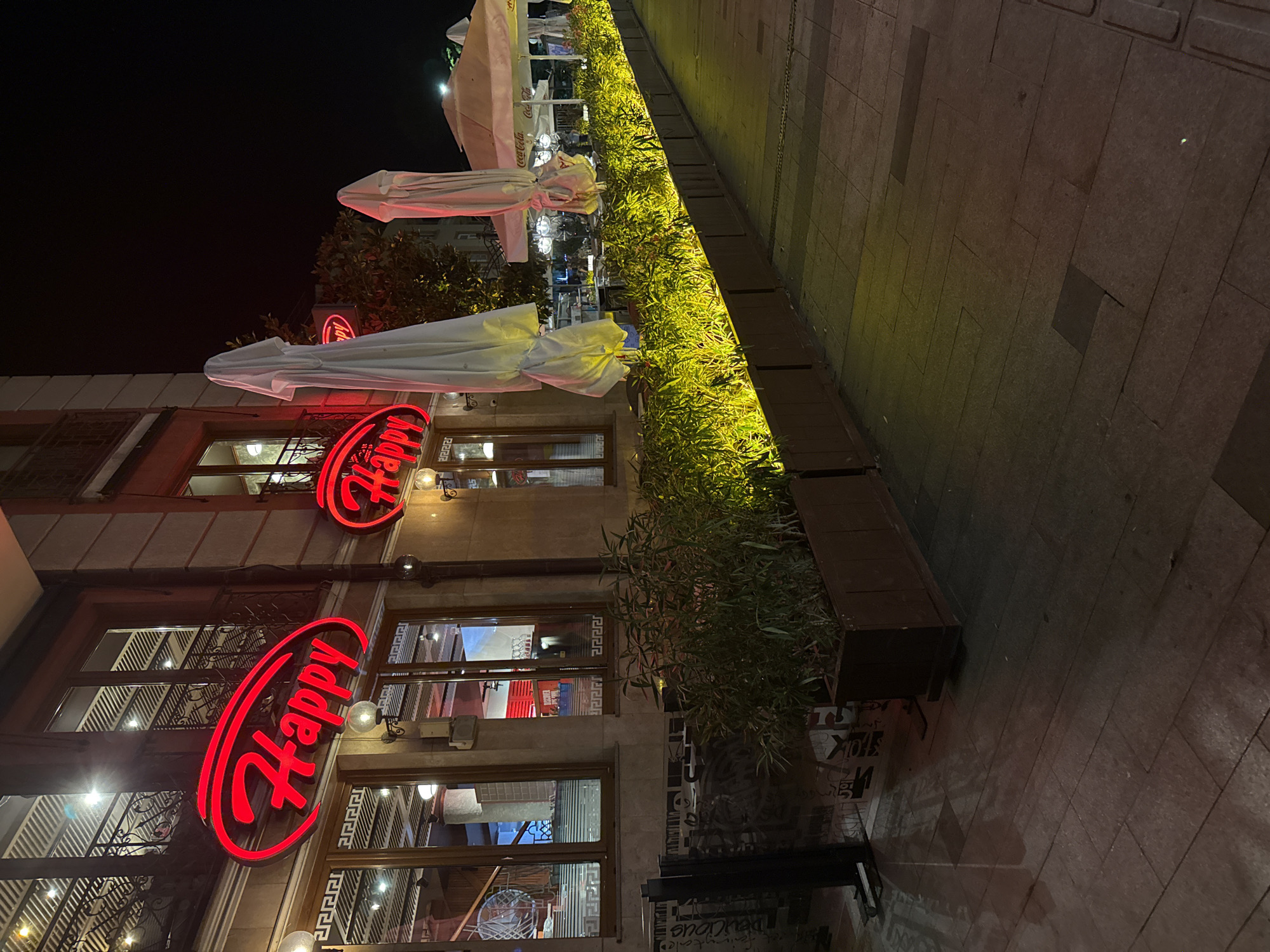 Nighttime city block with neon signs and quiet streets