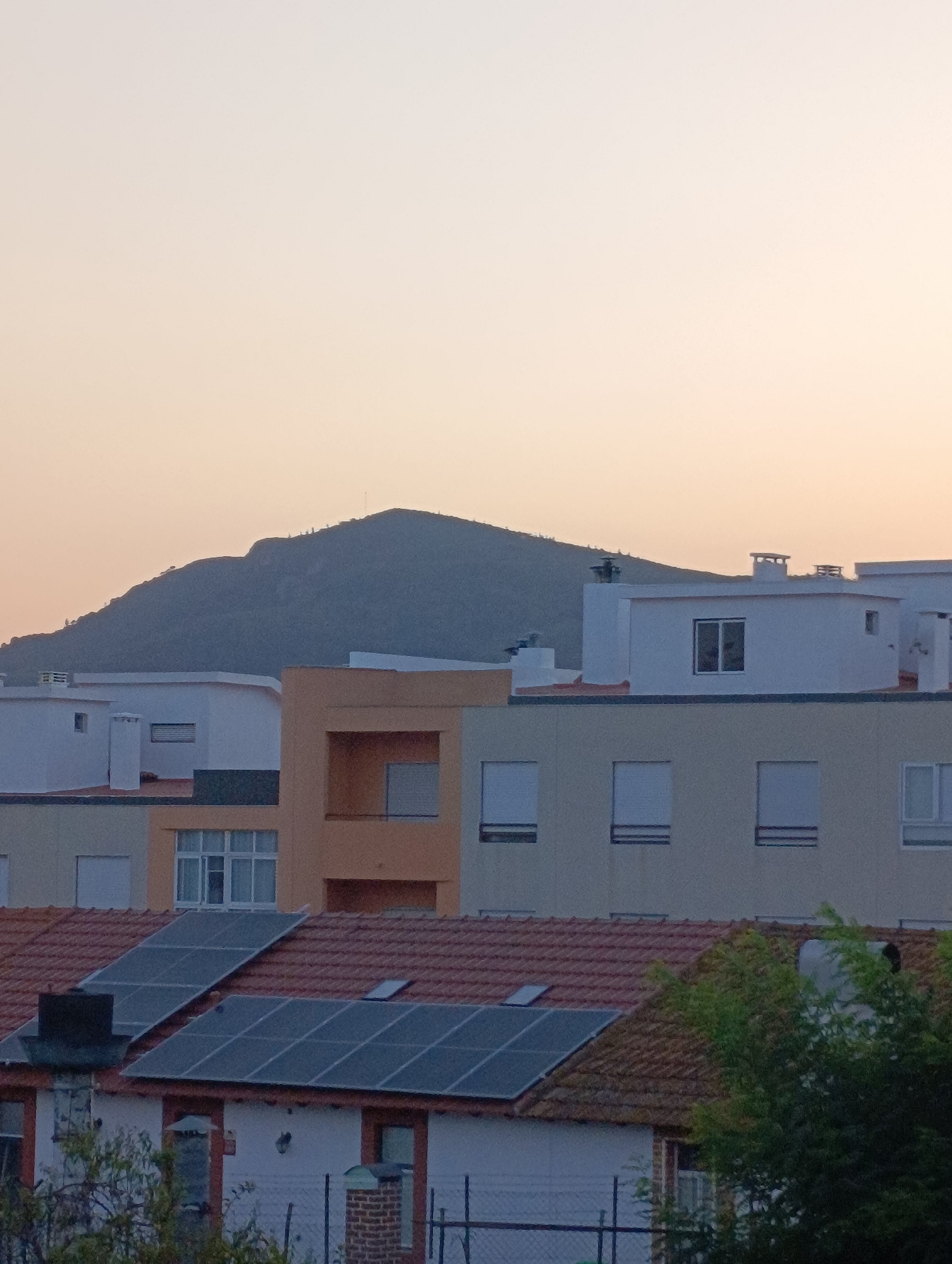 Setúbal neighborhood at dusk, rooftops and hillside in view