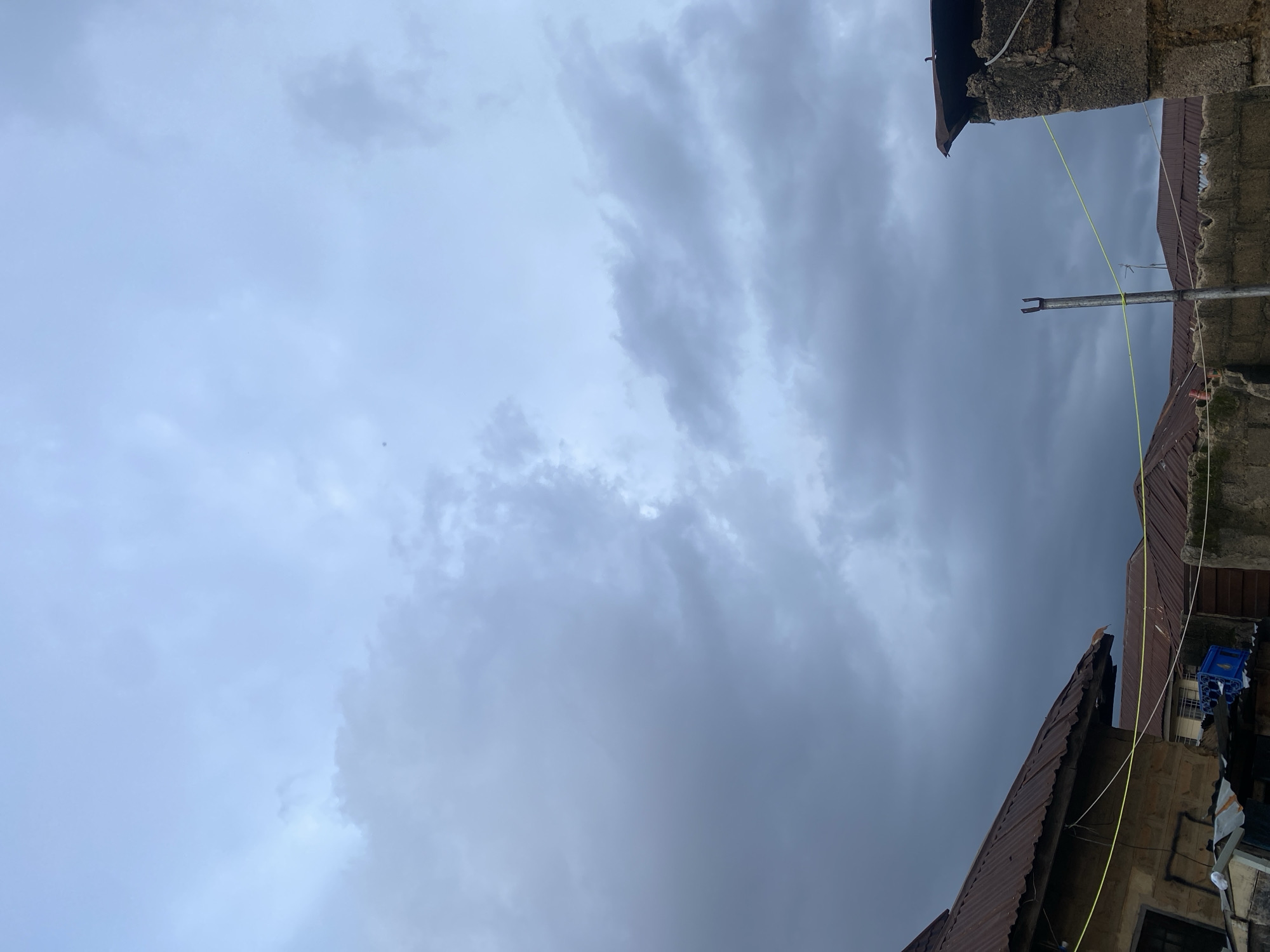 Street life and overcast skies across a Jos neighborhood