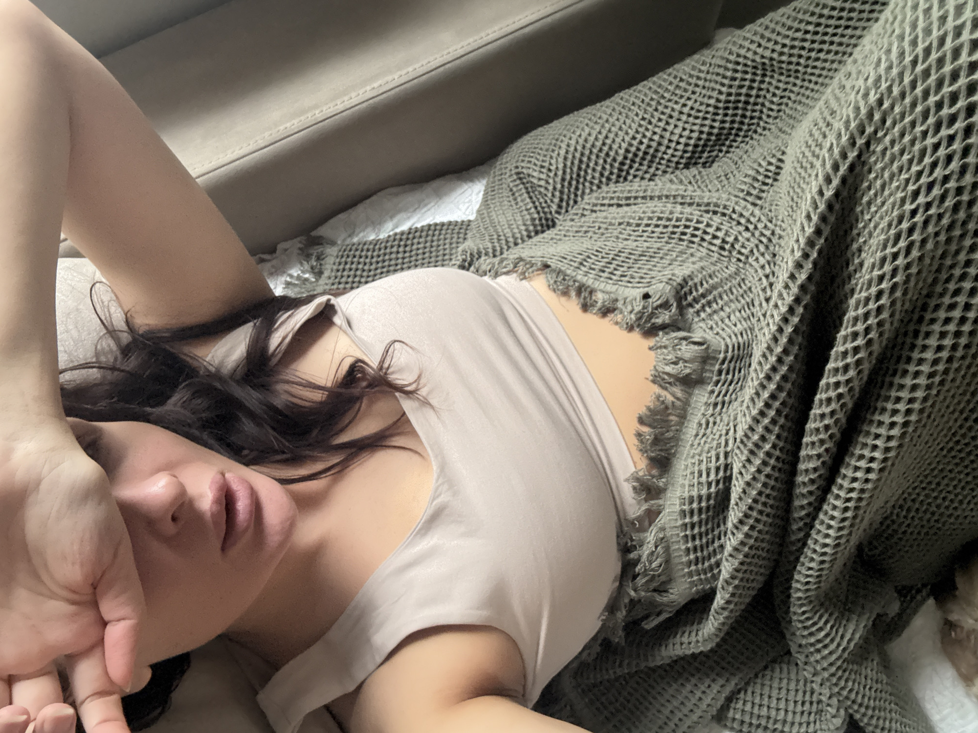 Woman rests with chihuahua on couch in Chaikovsky