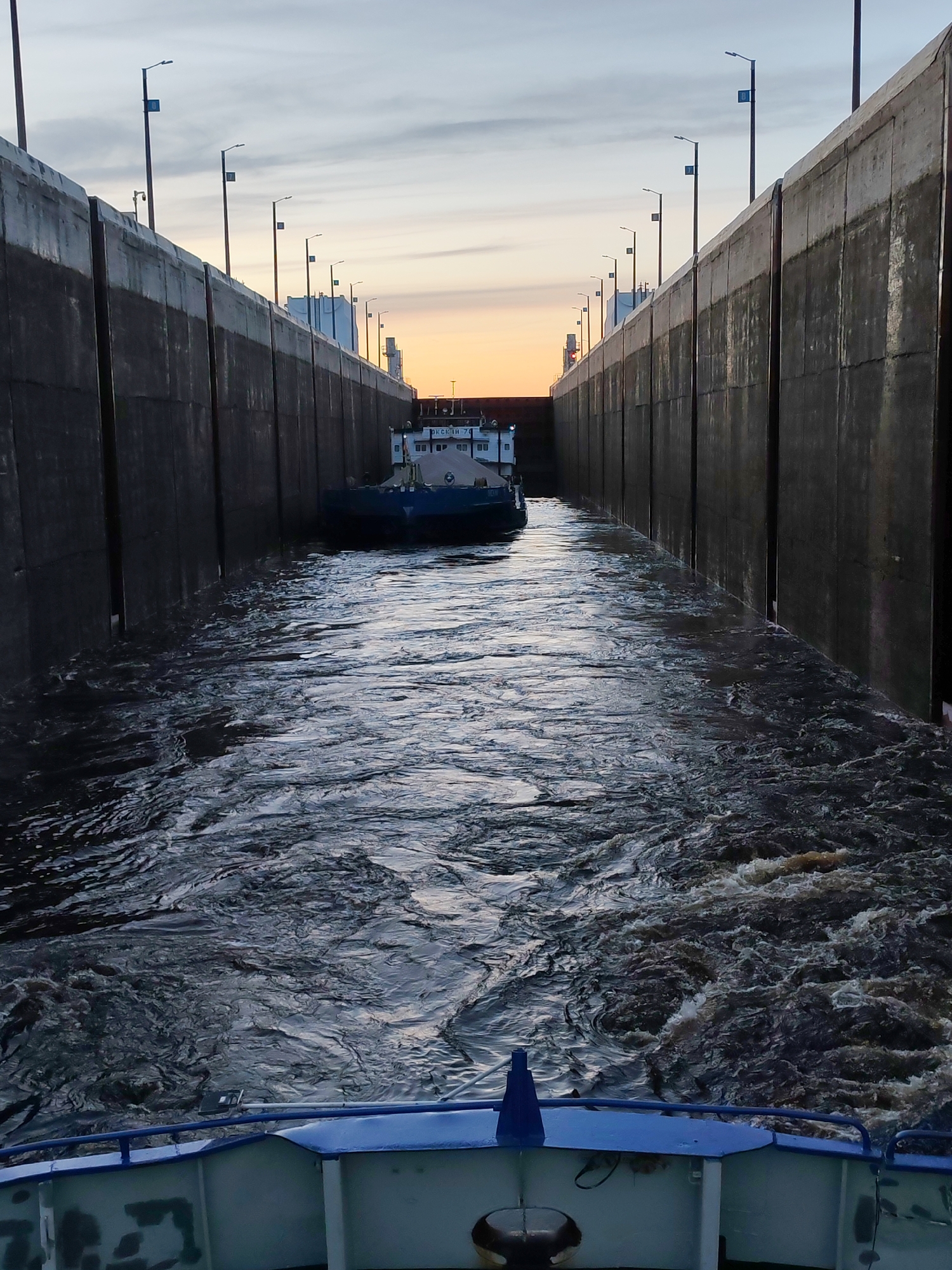 Cargo barges transit Volga-Baltic Waterway lock in Sheksna, Russia